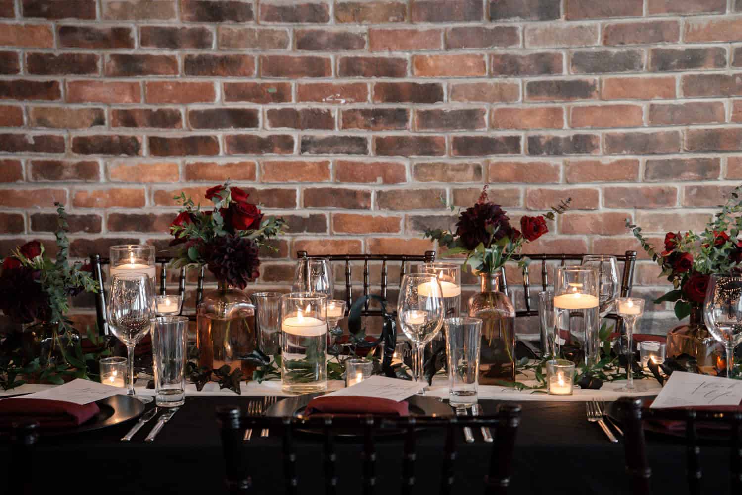 Decorated event table with flowers, candles, and glassware at SKY Armory.