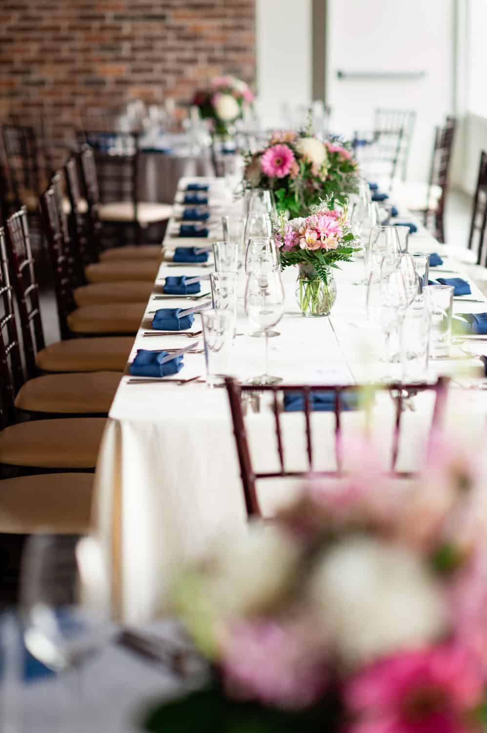 Beautifully decorated event table with floral centerpieces and place settings.