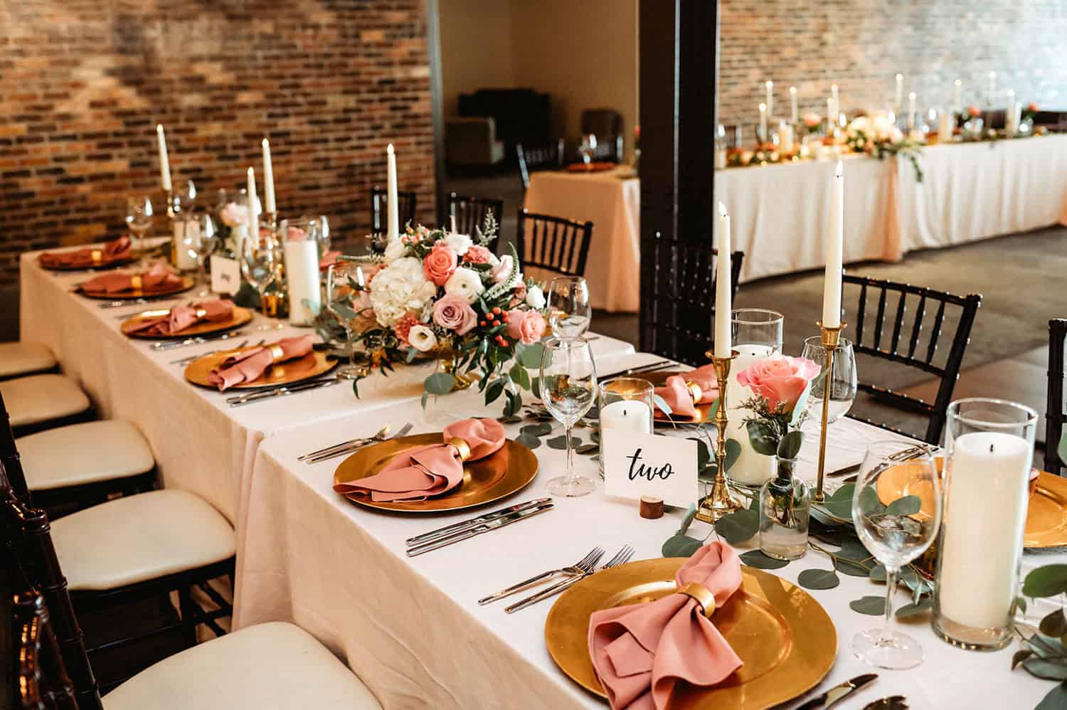 Beautifully decorated wedding reception table with floral centerpieces and candles.