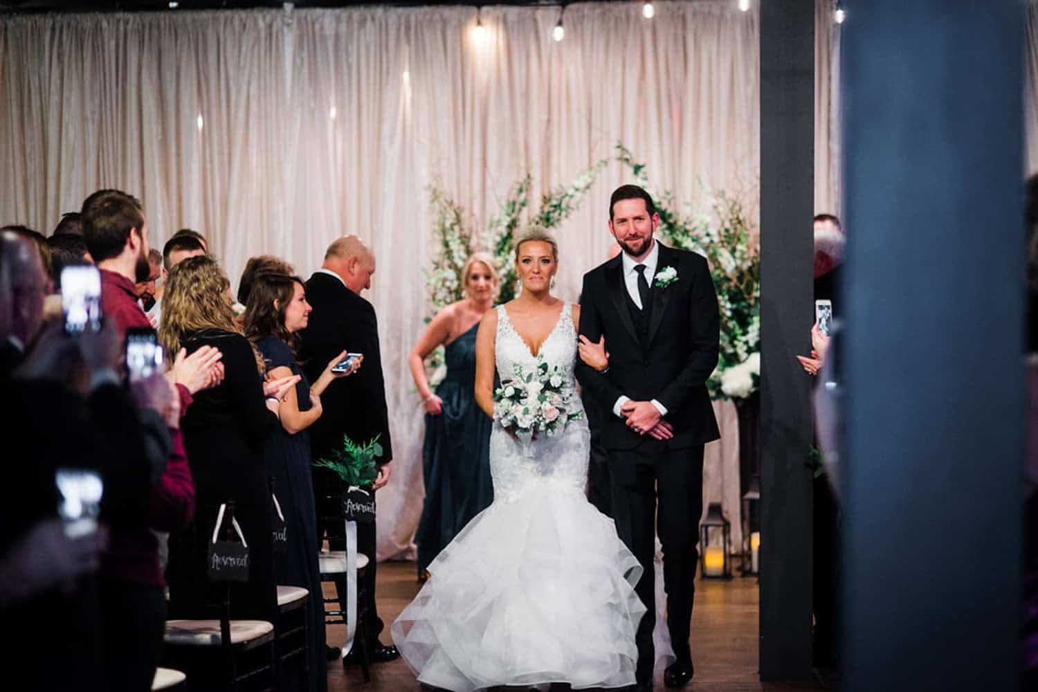Bride and groom walking down the aisle at SKY Armory wedding venue.