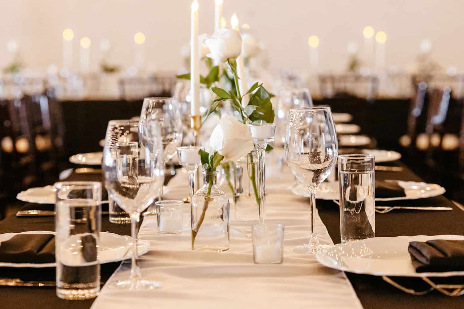 Beautifully arranged wedding reception table with candles and floral centerpiece.
