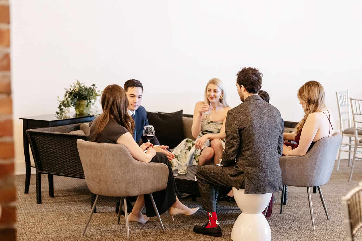 Group of friends enjoying drinks and conversation in a stylish lounge setting.