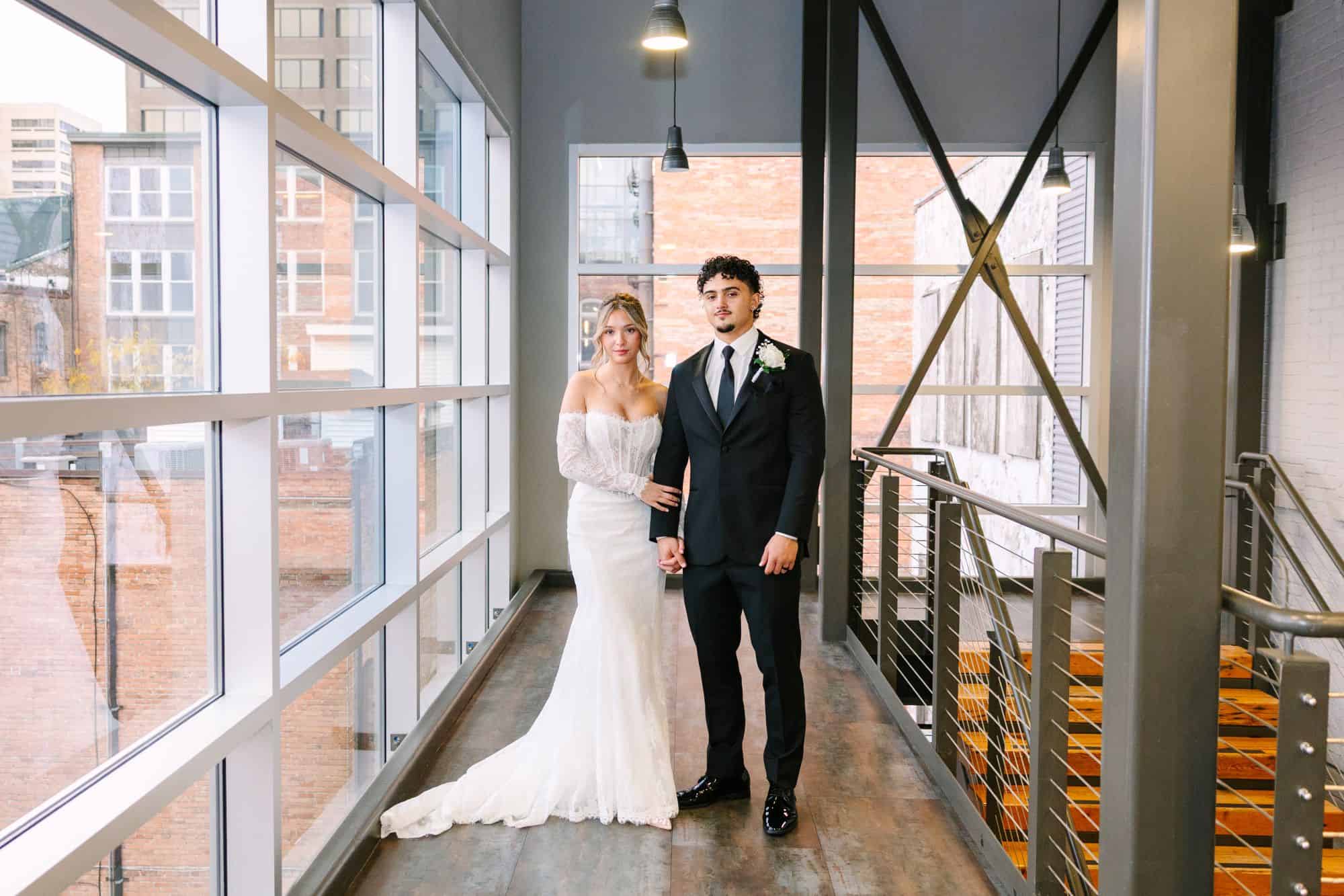 Bride and groom in wedding attire at SKY Armory with modern industrial decor.