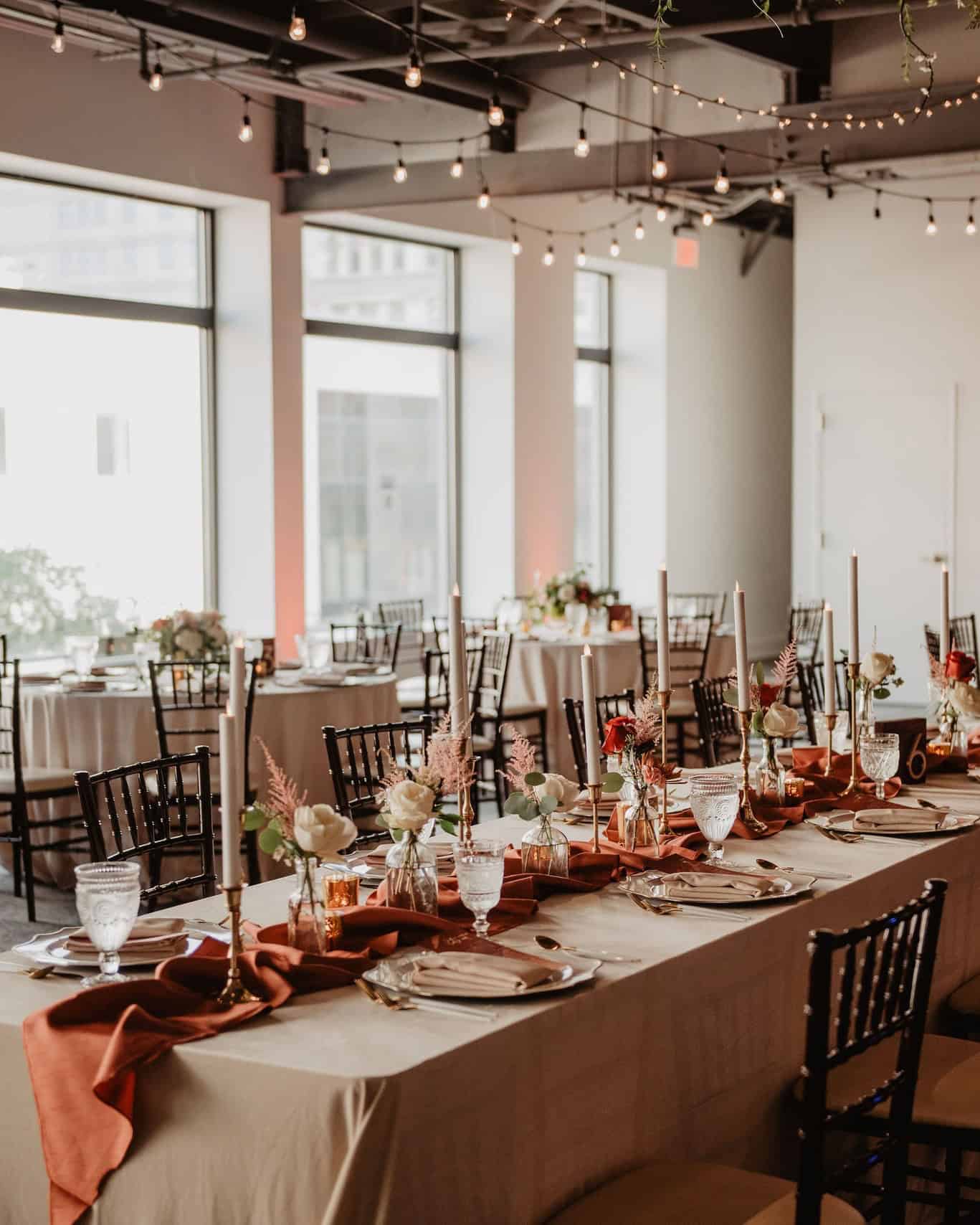 Beautifully decorated event table with floral arrangements and candleholders at SKY Armory.