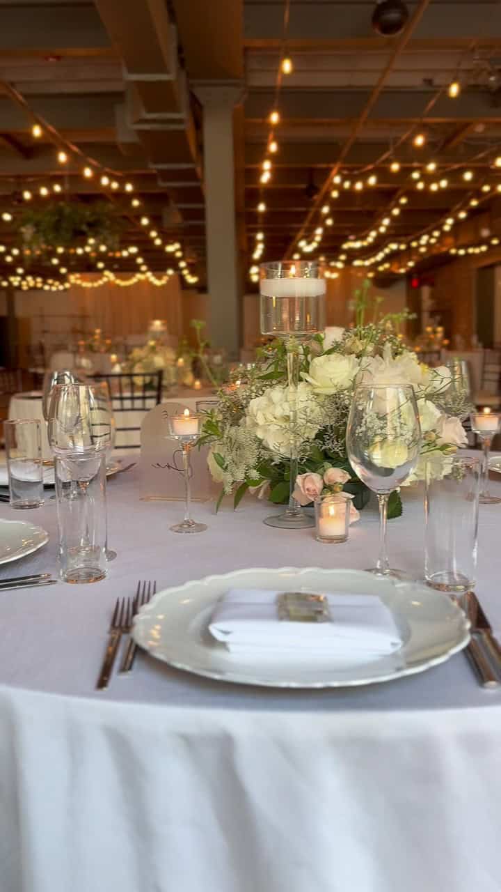 Beautiful wedding table with floral centerpiece and string lights at SKY Armory.