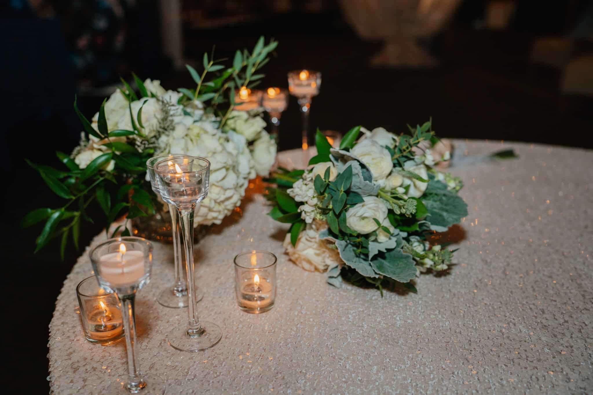 Beautiful wedding table with floral arrangements and candles for romantic ambiance.