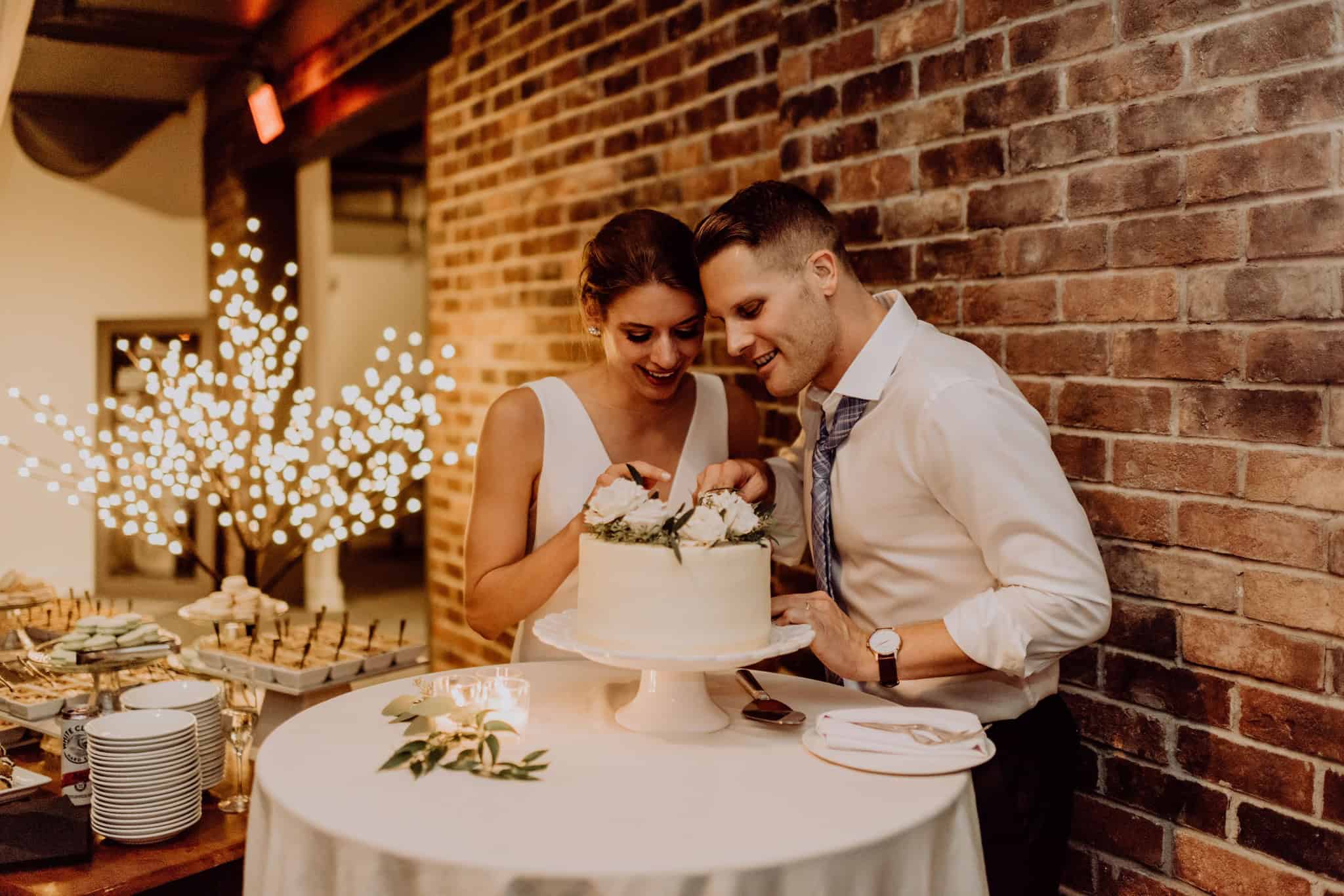 Happy couple cutting wedding cake at SKY Armory event.