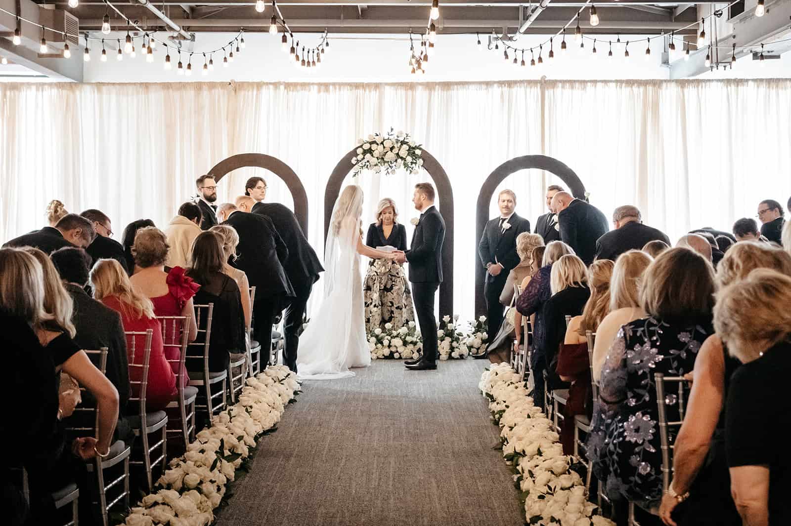 Elegant wedding ceremony at Sky Armory with guests and floral decor.