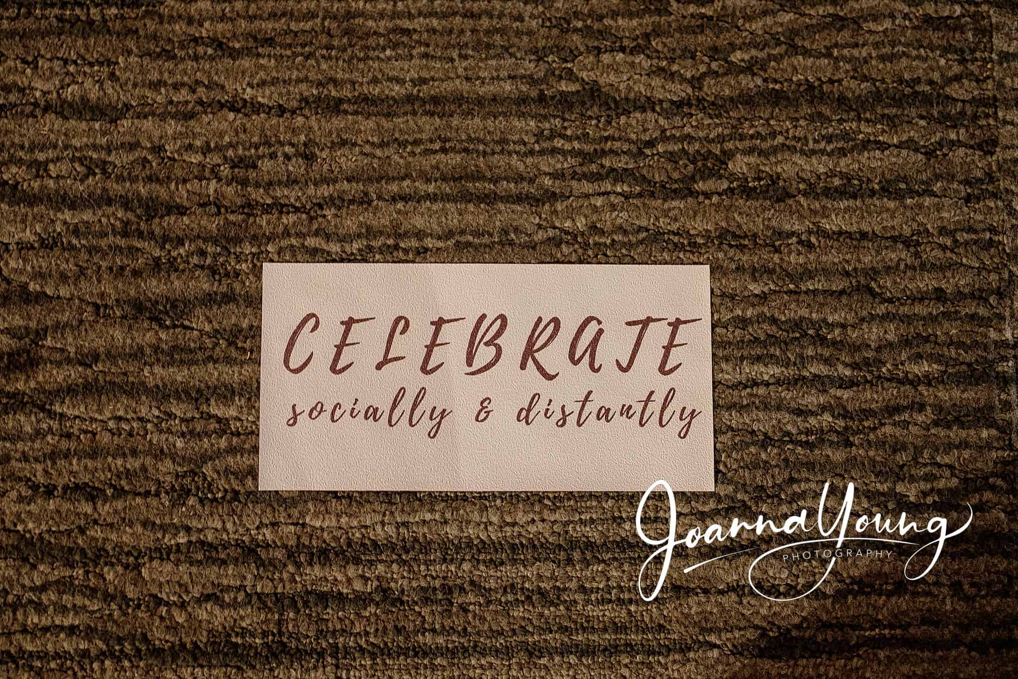 Celebrating socially and distantly with a handwritten note on a wooden surface.