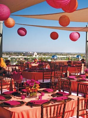 Outdoor summer wedding reception with colorful lanterns and elegant table settings.