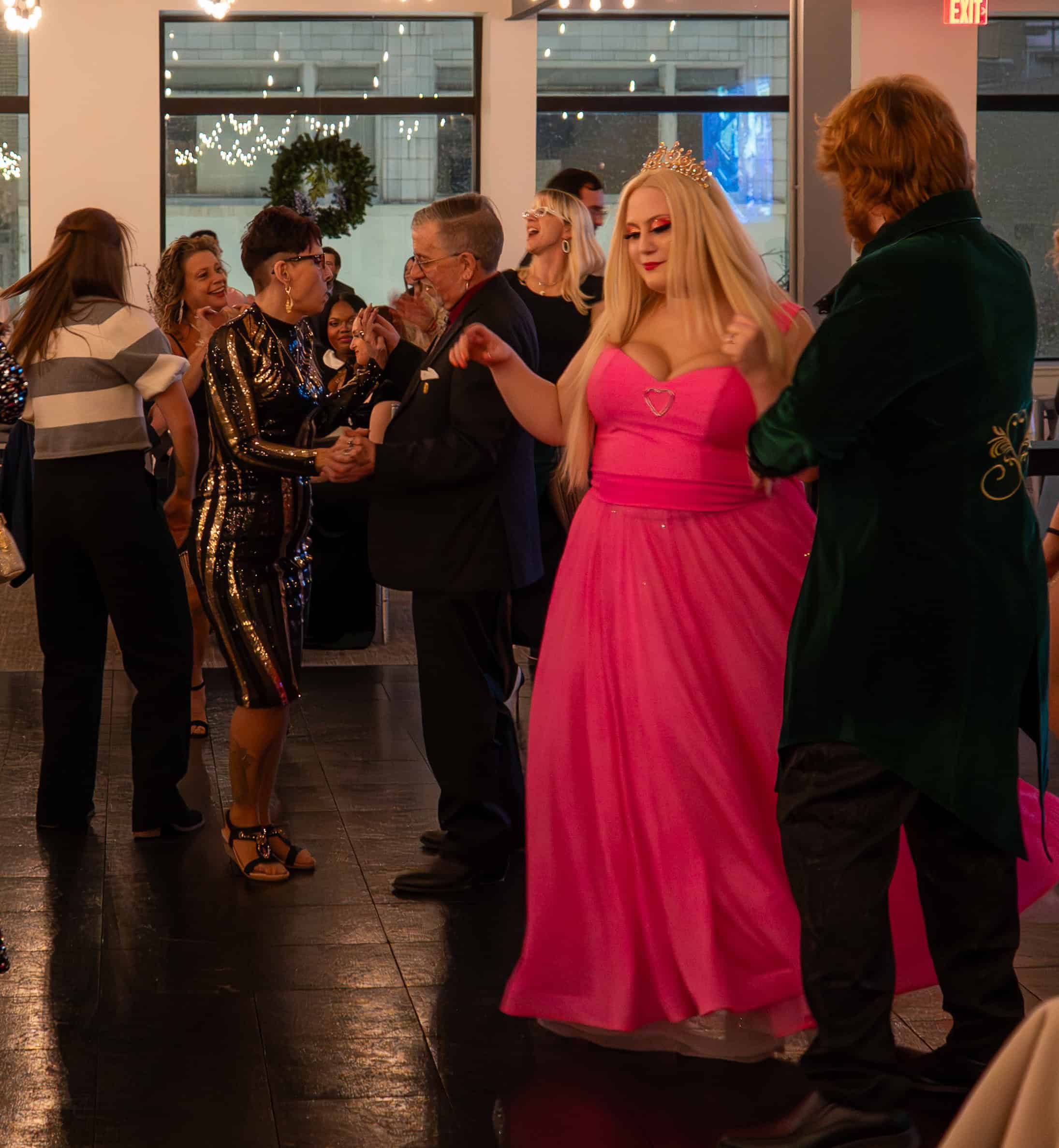 People dancing and socializing at Sky Armory event in elegant outfits.