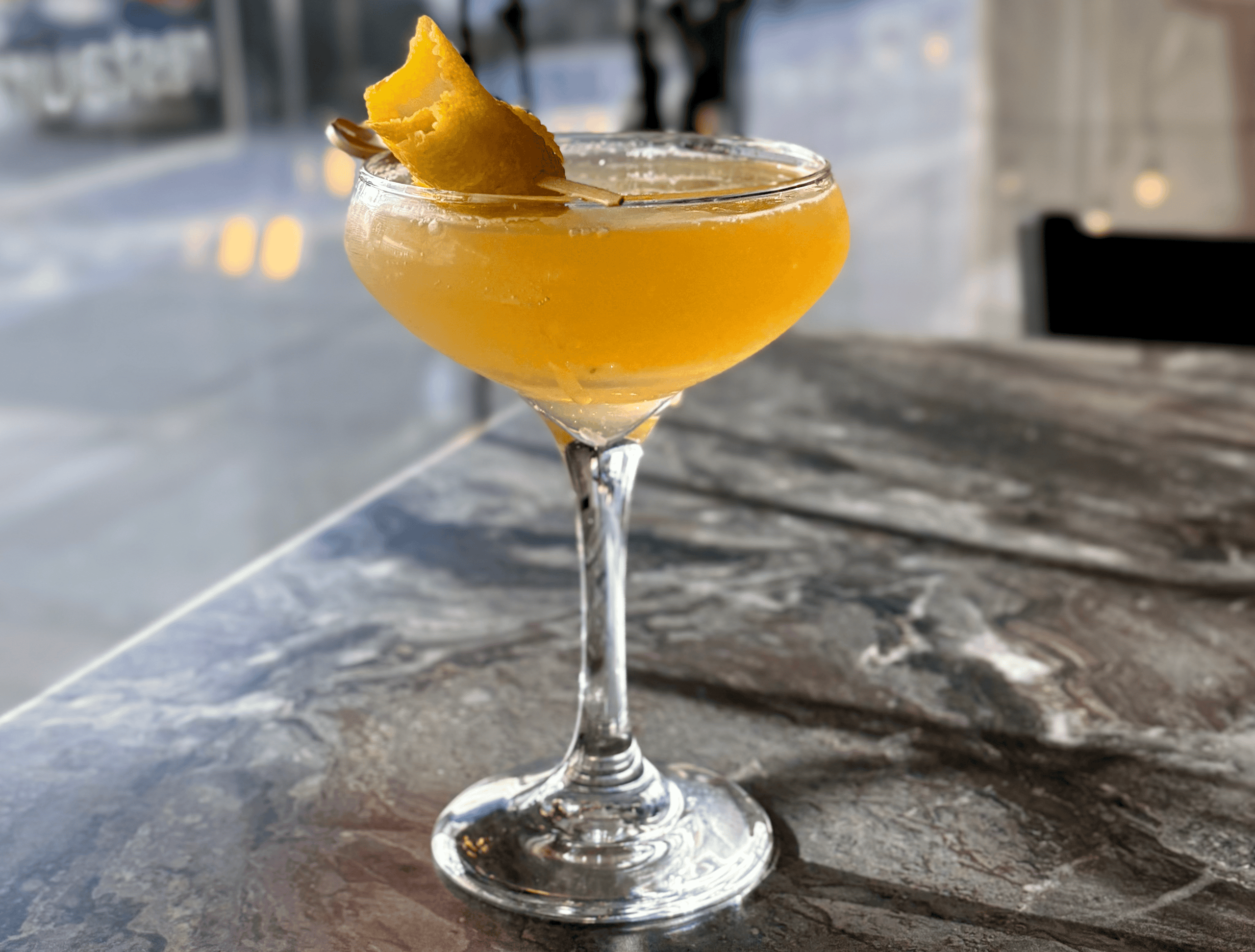 Elegant cocktail in a glass with lemon twist at Sky Armory.