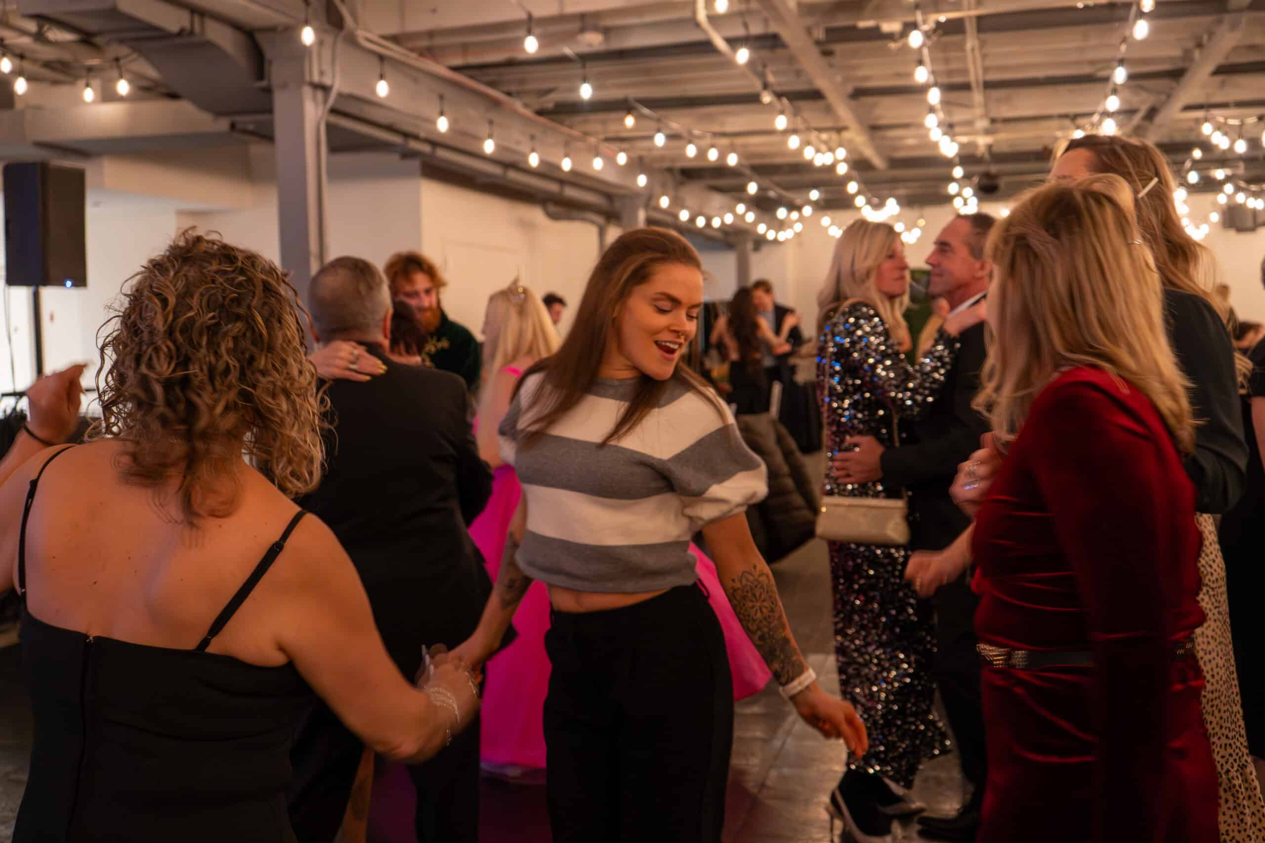 People dancing and socializing at SKY Armory event in a decorated venue.