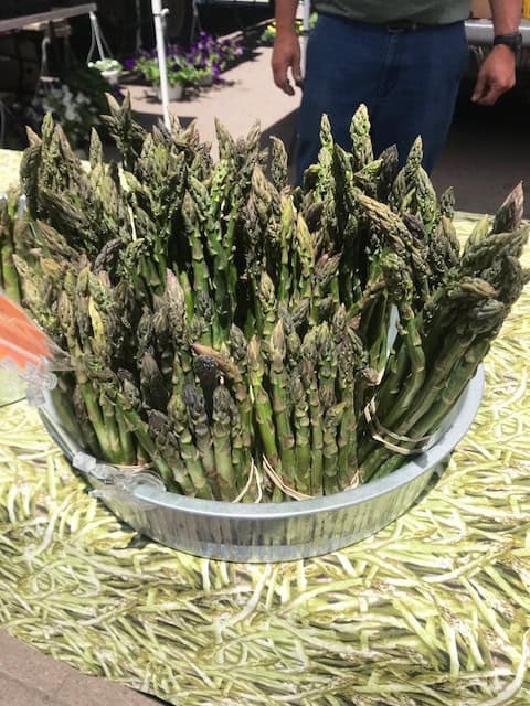 Fresh green asparagus displayed at the farmers market for sale.