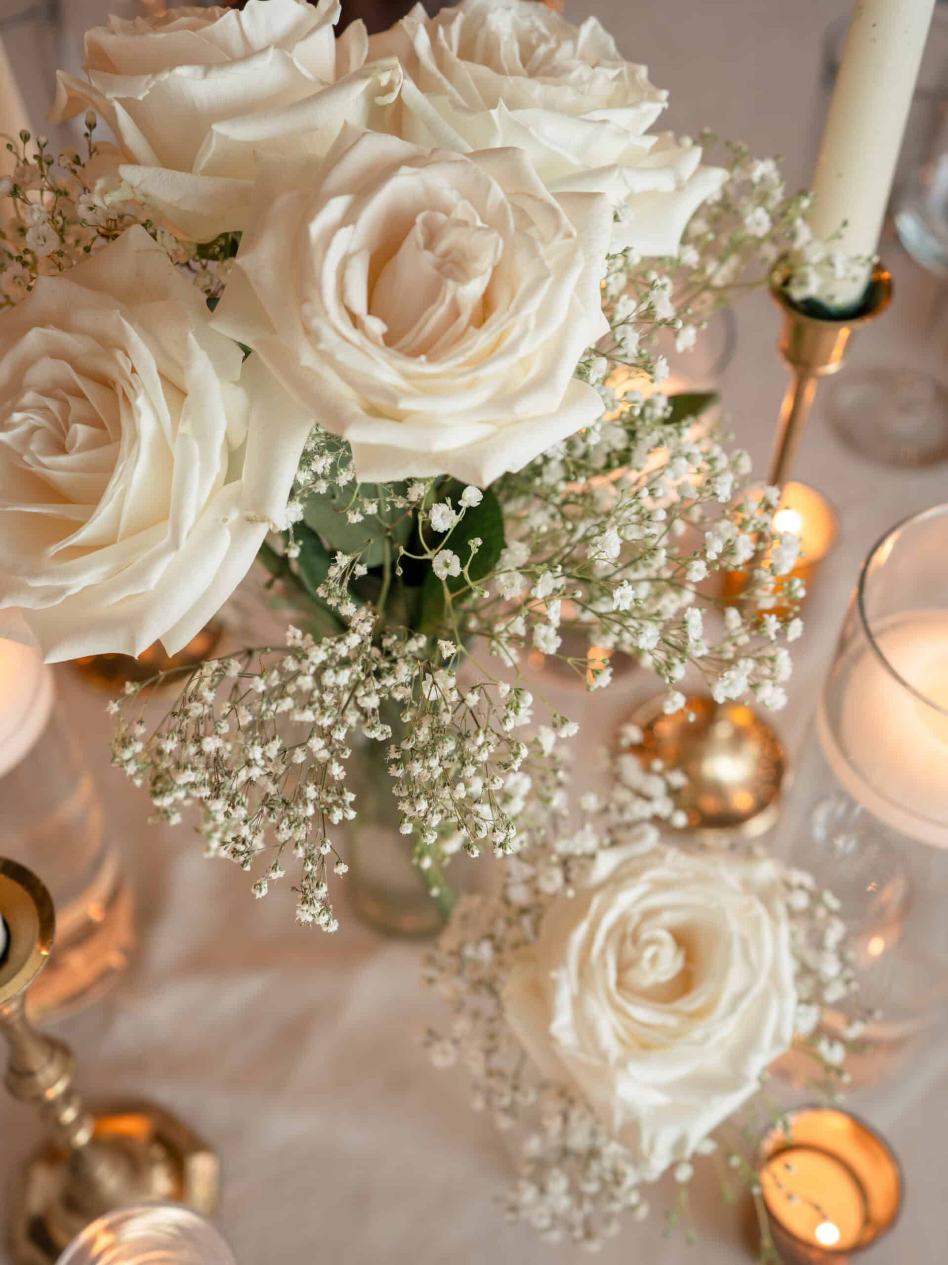 Beautiful white roses with baby's breath in a floral centerpiece for special occasions.