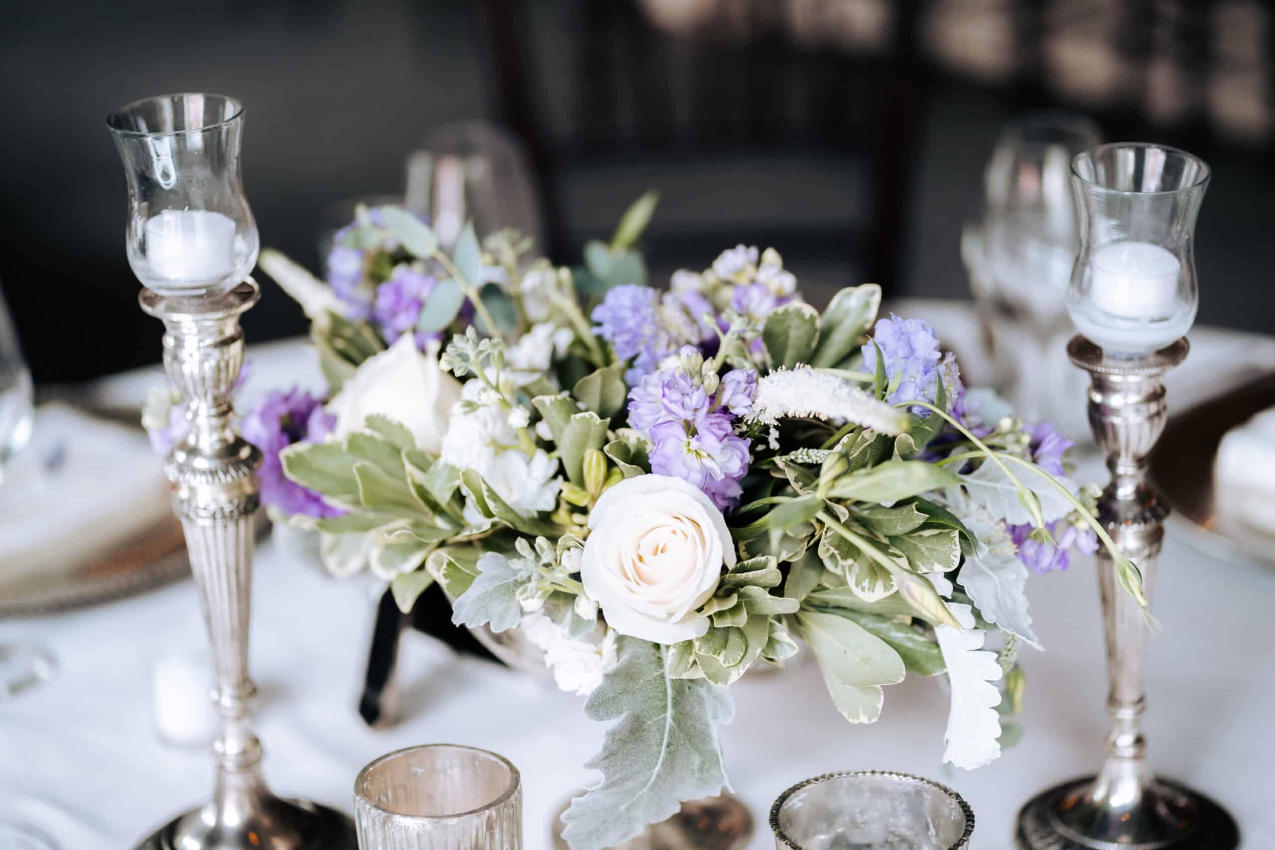 Beautiful floral centerpiece with white roses and purple flowers for SKY Armory event.