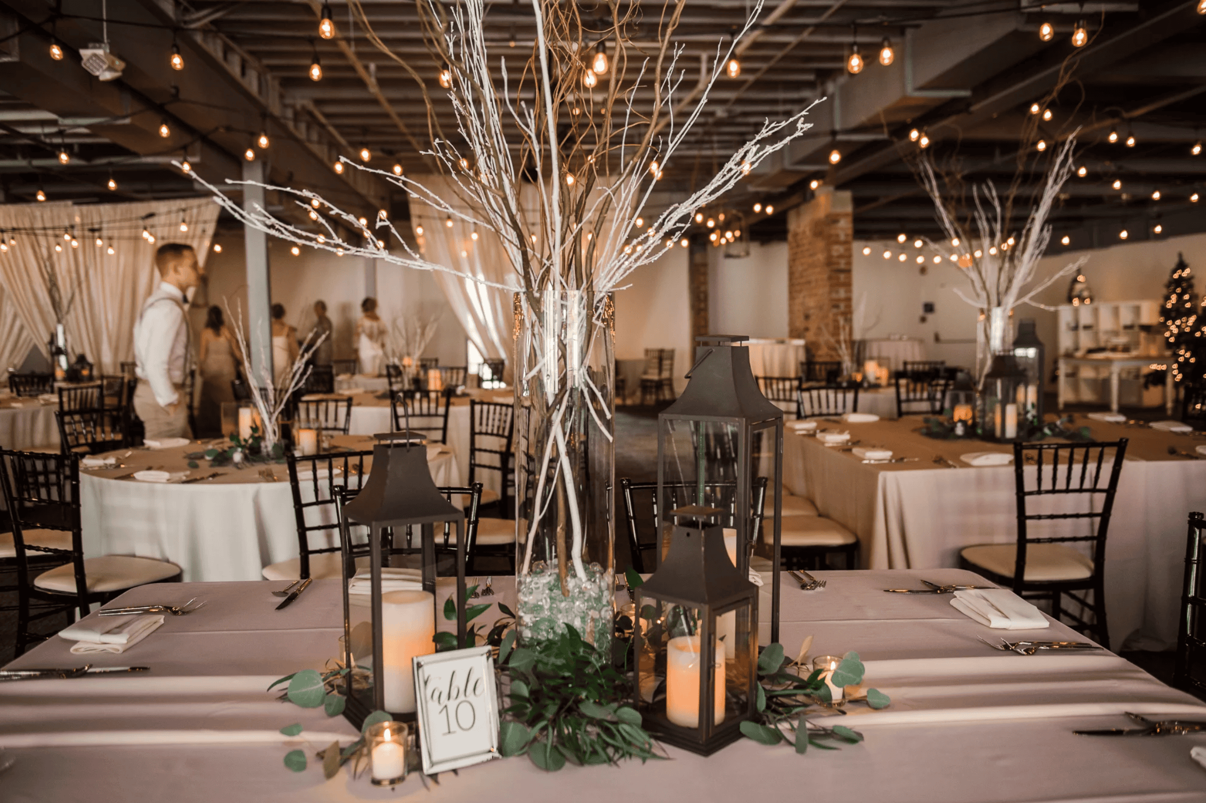 Elegant winter wedding decor with illuminated branches and cozy lighting at SKY Armory.