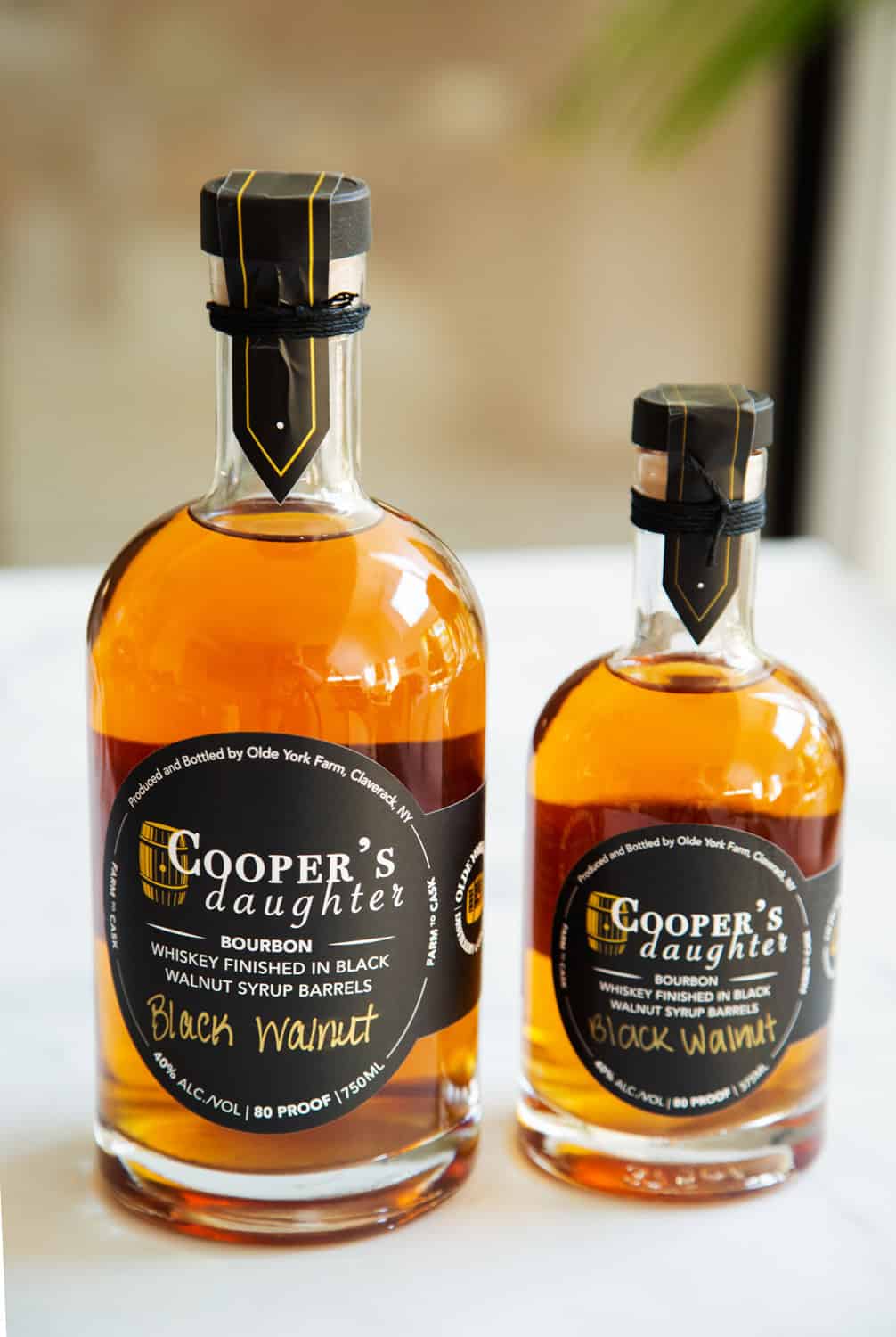 Cooper's Daughter Black Walnut Bourbon bottles on a white surface.