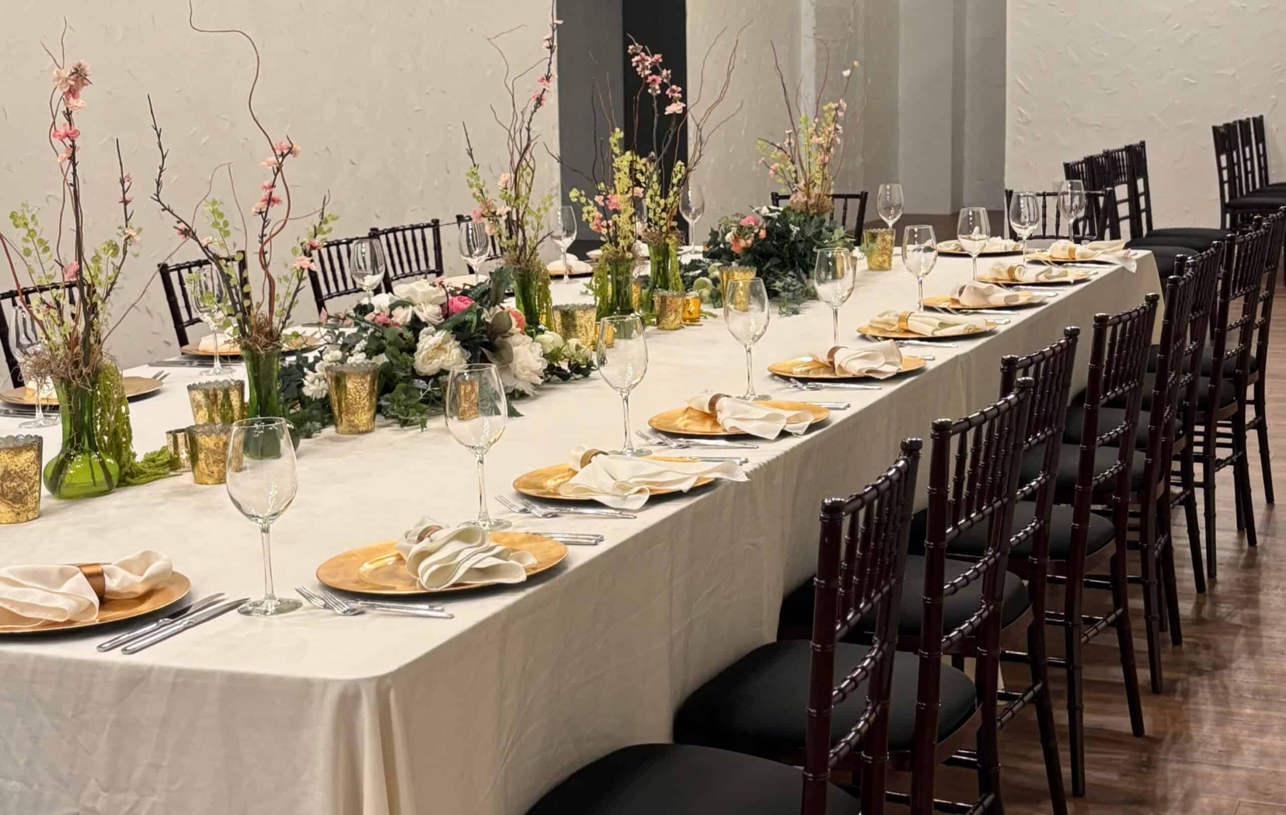 Formal dining table with floral centerpieces and place settings.