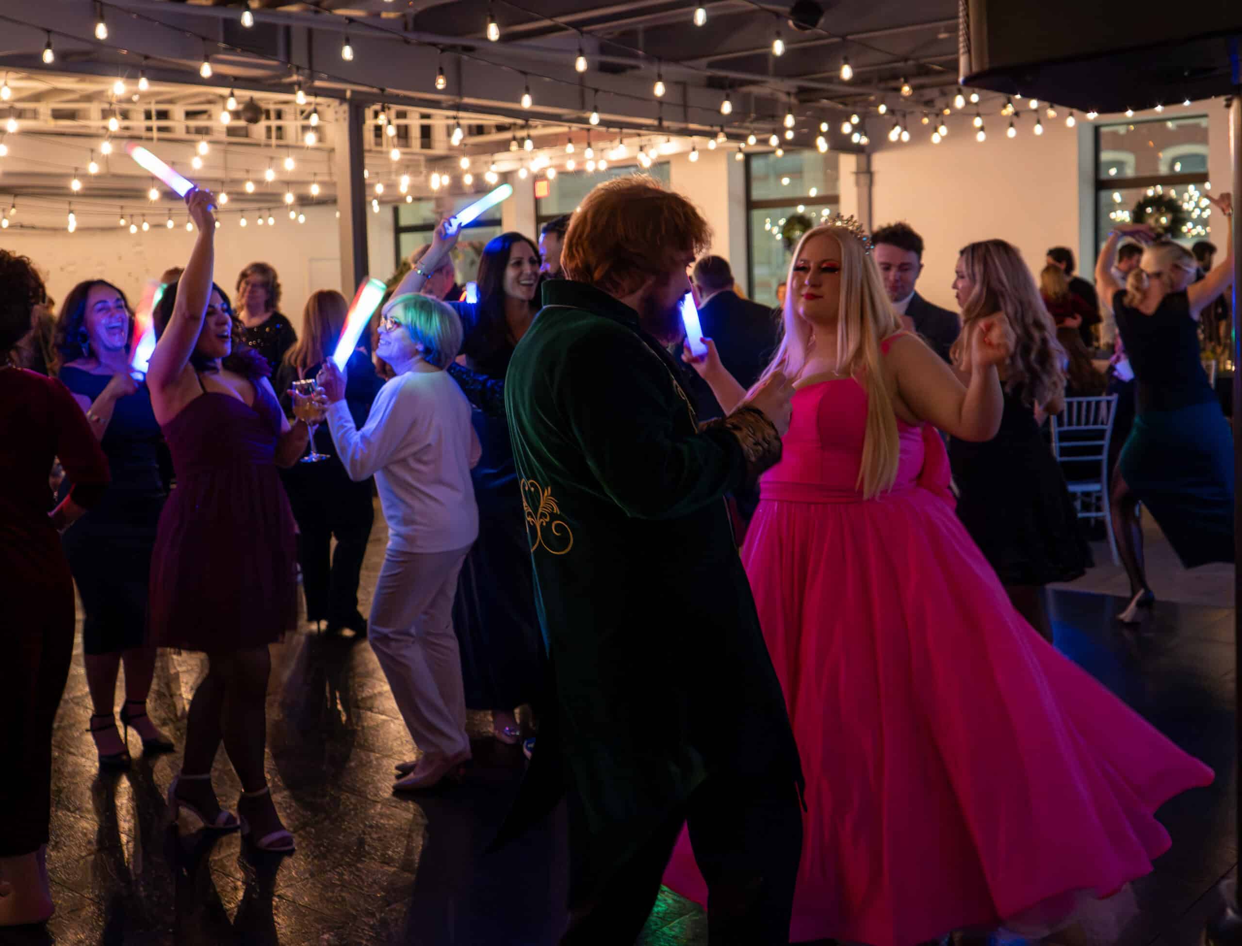 People dancing at SKY Armory with glow sticks and vibrant lighting.
