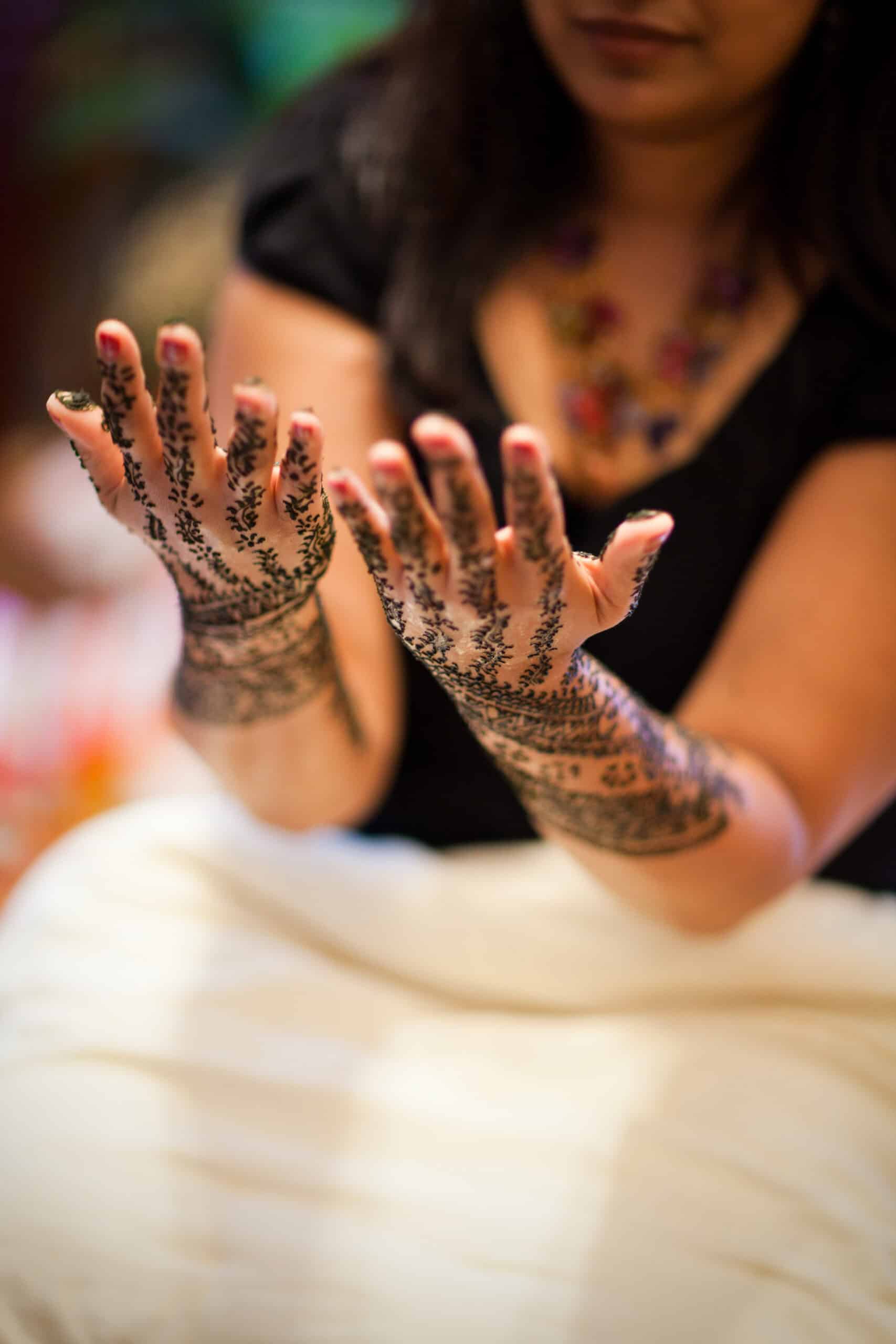 Close-up of hands with intricate henna designs for a wedding.