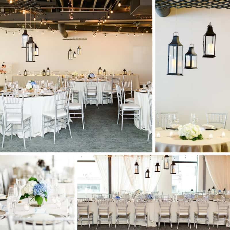 Chic event space with hanging lanterns and white table settings for a wedding or celebration.