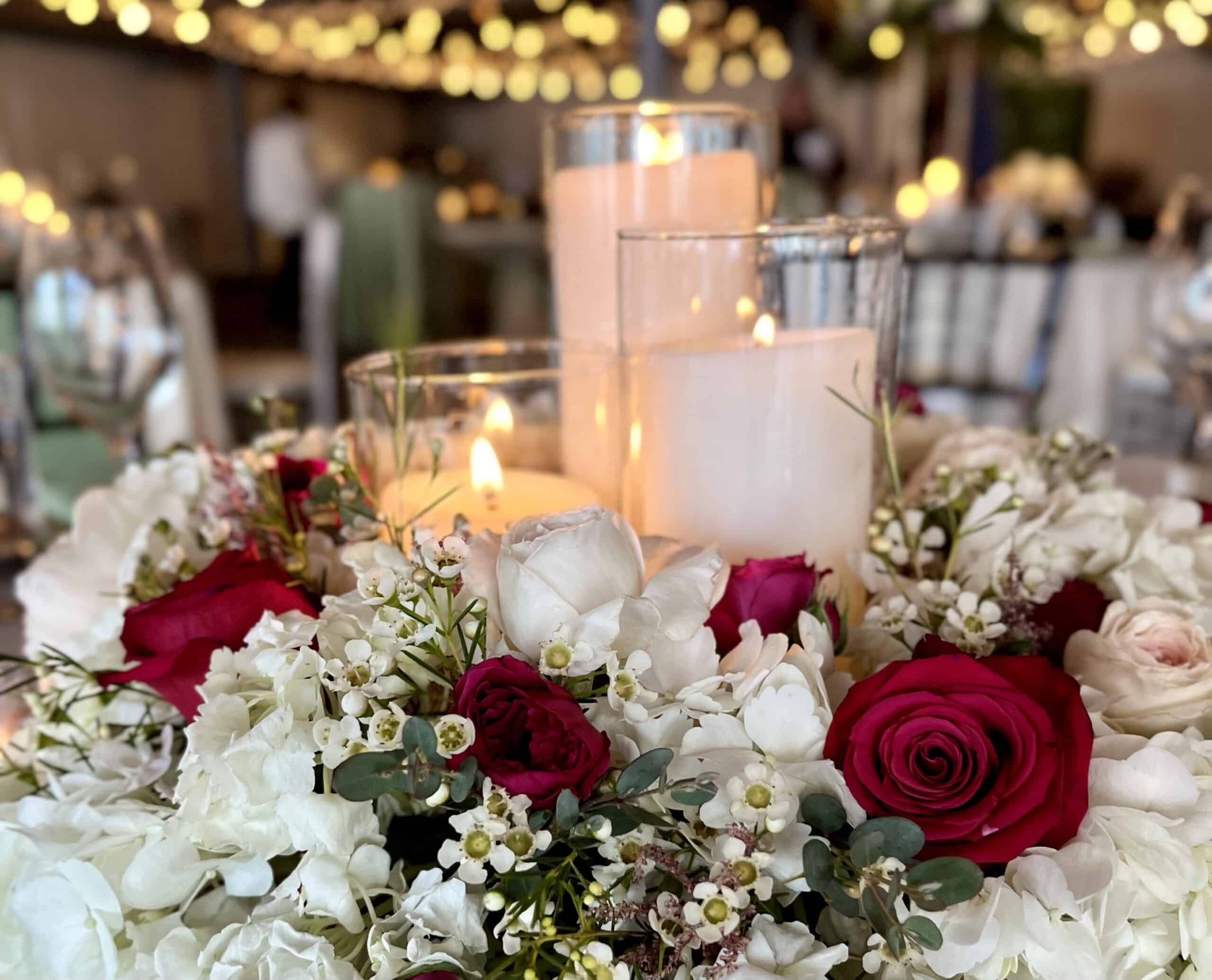 Beautiful floral wedding centerpiece with candles and roses for elegant decor.
