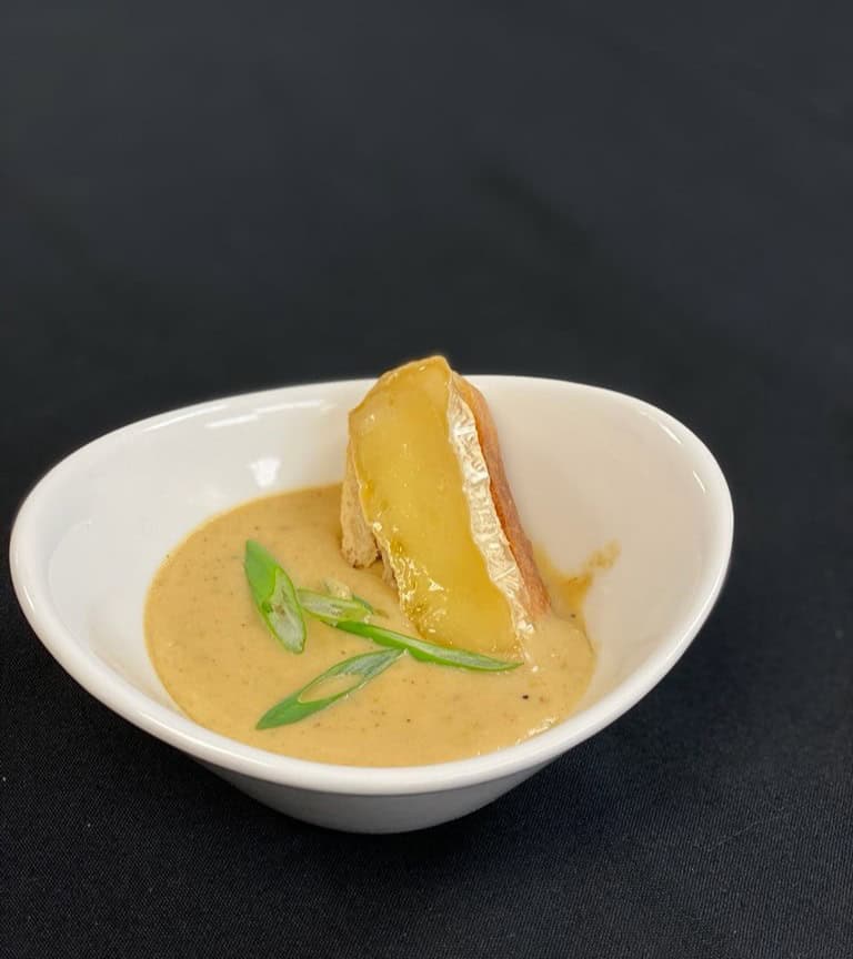 Dessert with caramelized pineapple and cream in a white bowl.