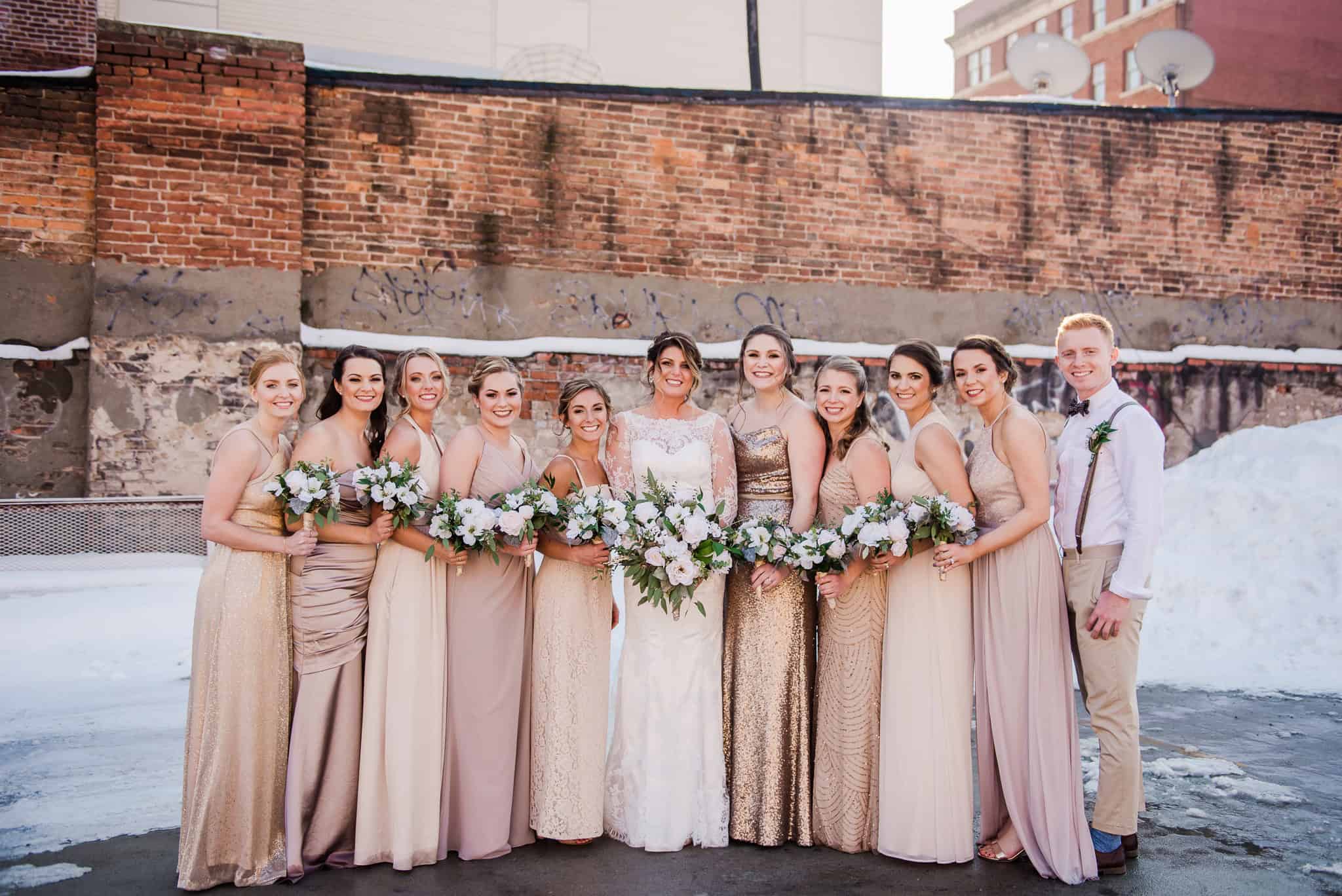 Bridal party in elegant dresses at industrial winter wedding.