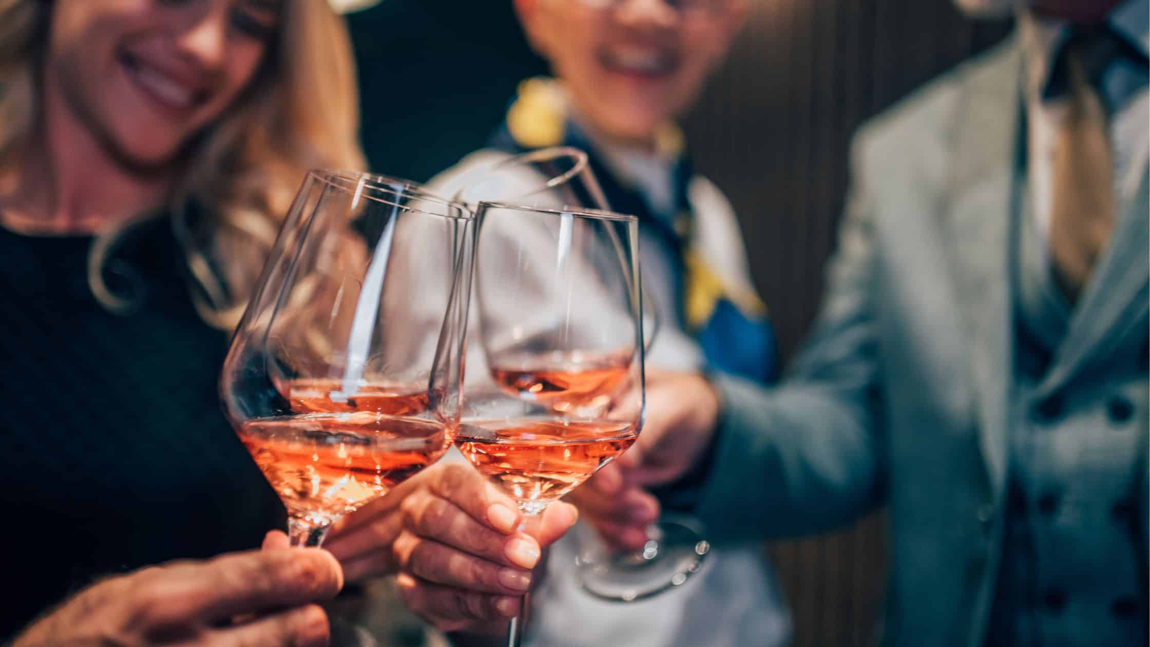 Group of people clinking glasses with rosé wine at SKY Armory event.