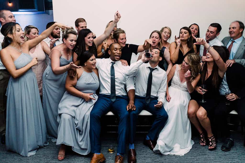 Group of wedding guests celebrating and taking photos at SKY Armory venue.