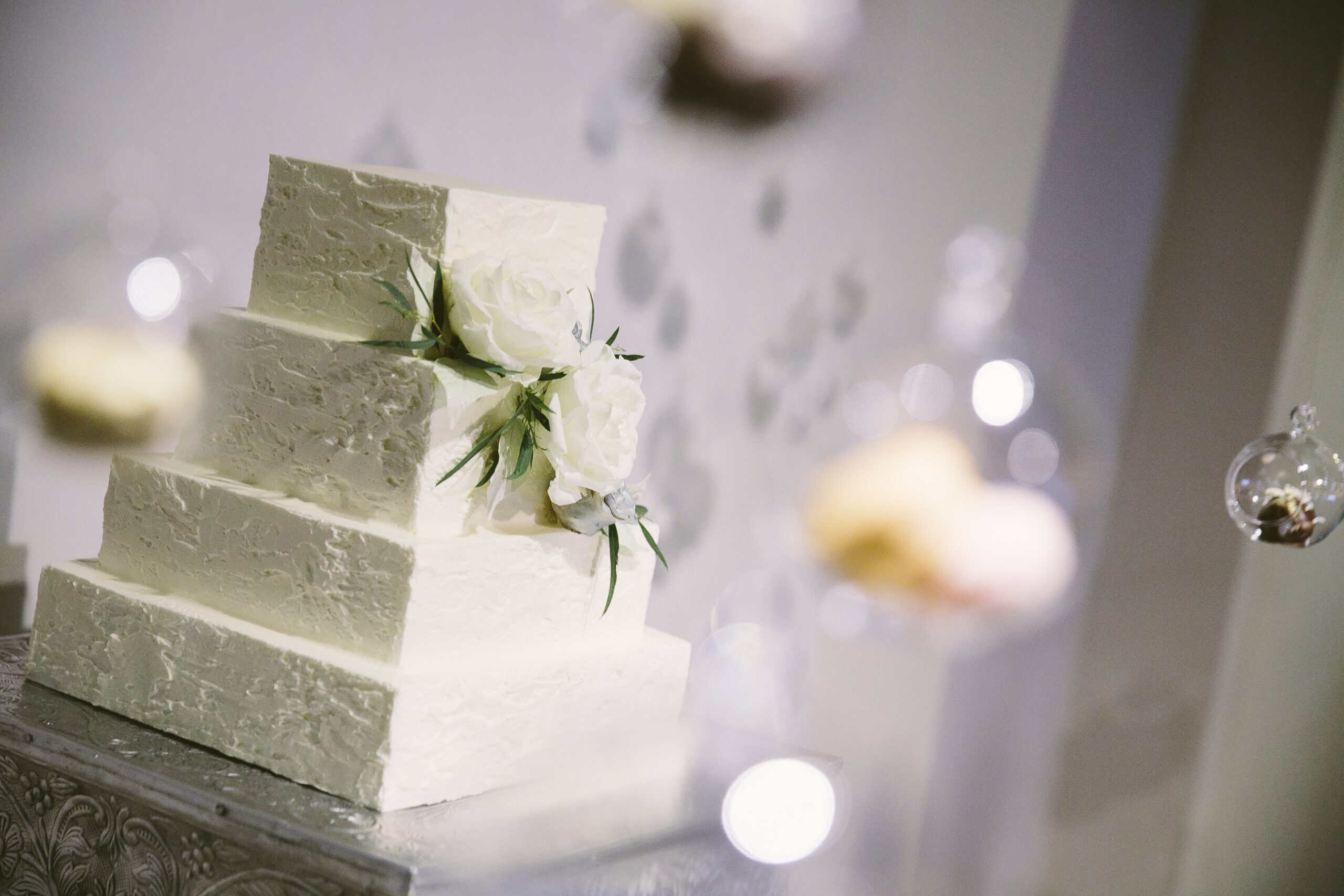 White tiered wedding cake with floral decorations at SKY Armory.