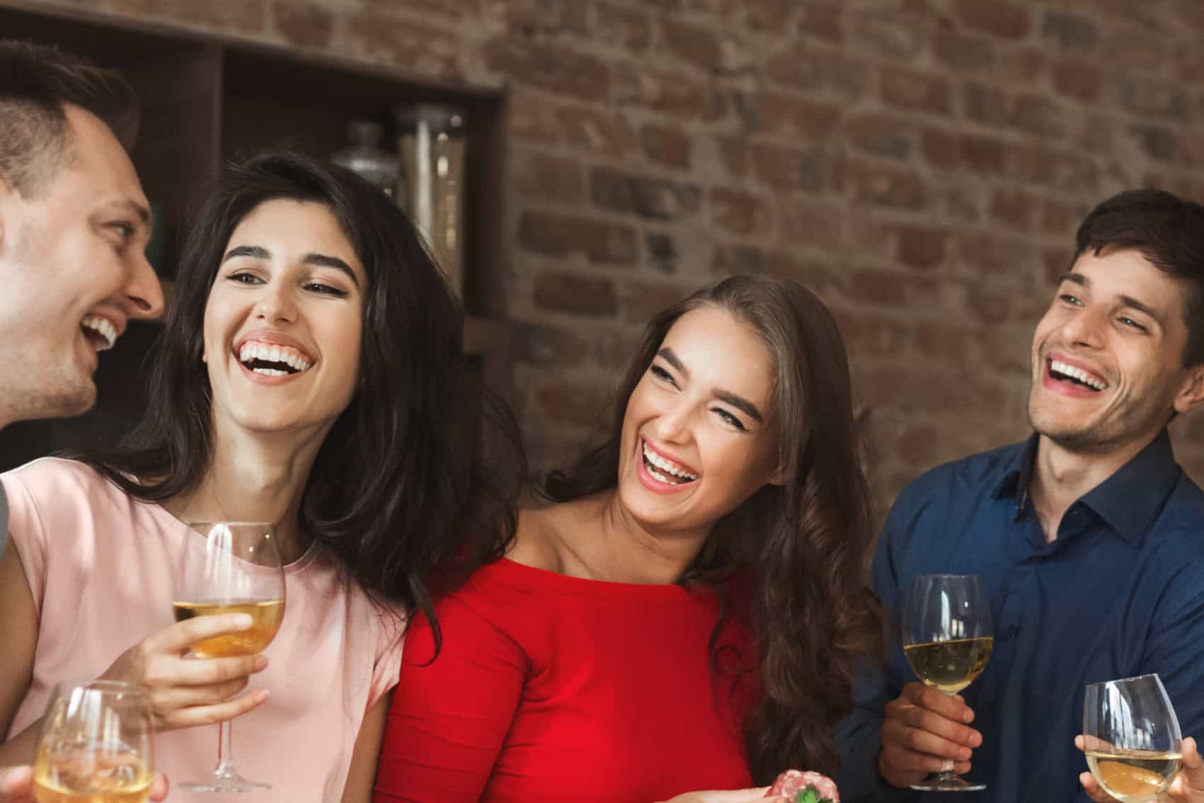 Friends celebrating with drinks, smiling, and having fun at a social gathering.