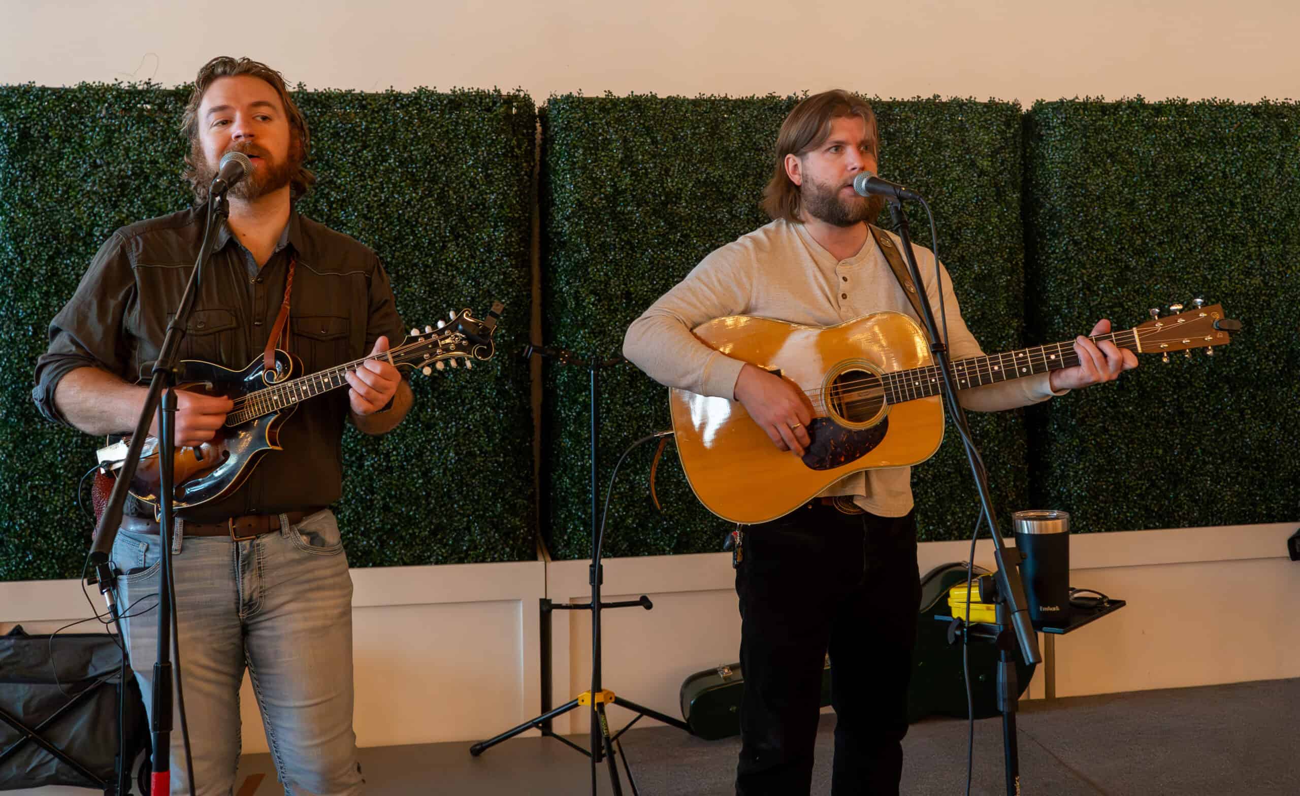 Two musicians performing with guitars at SKY Armory during parade day.