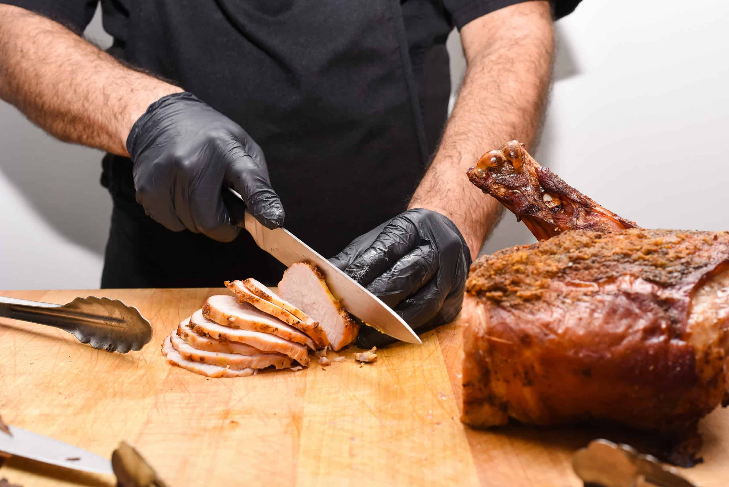 Chef slicing cooked meat with a knife at Sky Armory restaurant.
