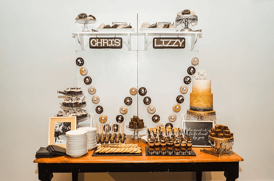 Decorative dessert table with personalized signs and treats for a party.