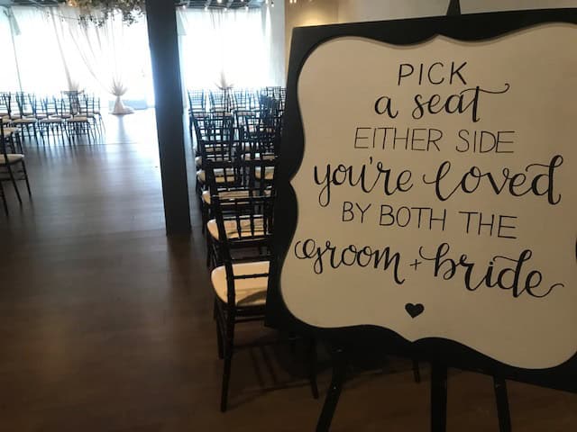 Wedding seating sign at SKY Armory with elegant script and chairs in background.