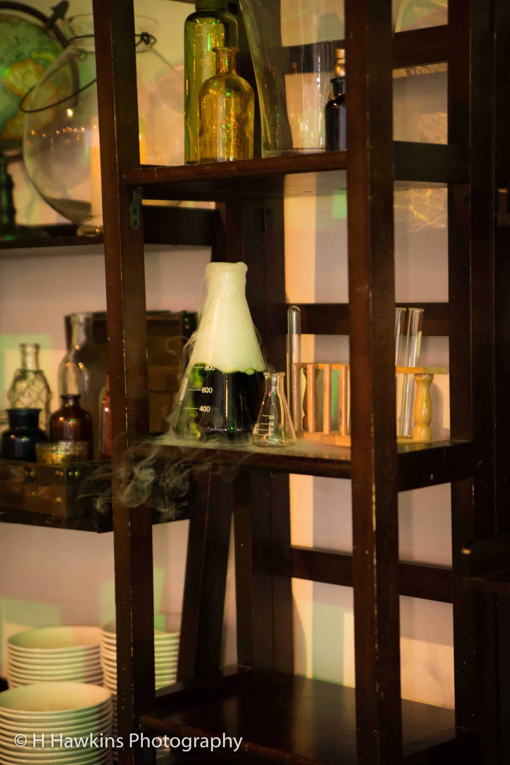 Laboratory glassware and equipment on wooden shelves at Sky Armory.