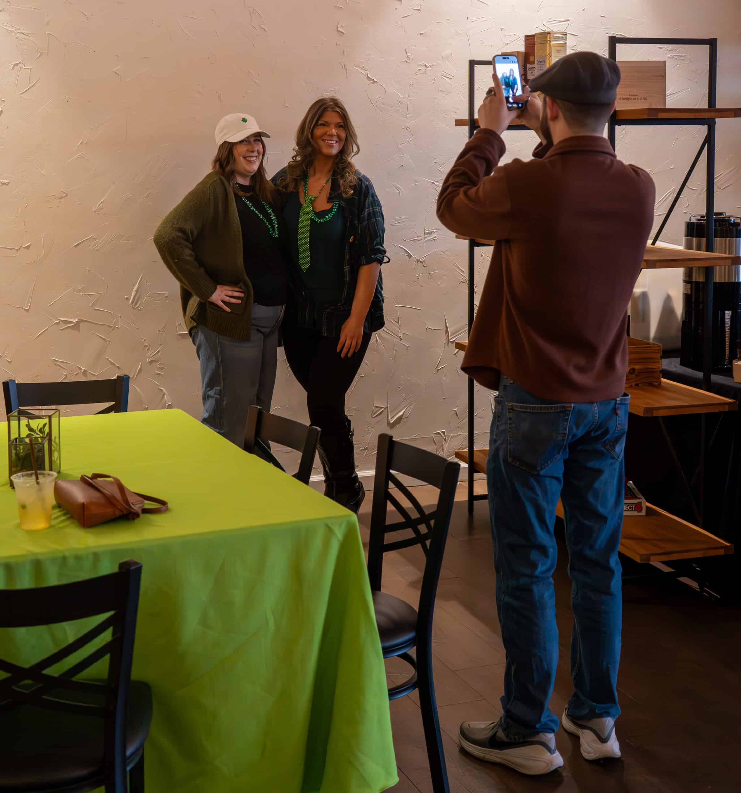 Two women posing for a photo at SKY Armory with a man taking their picture.