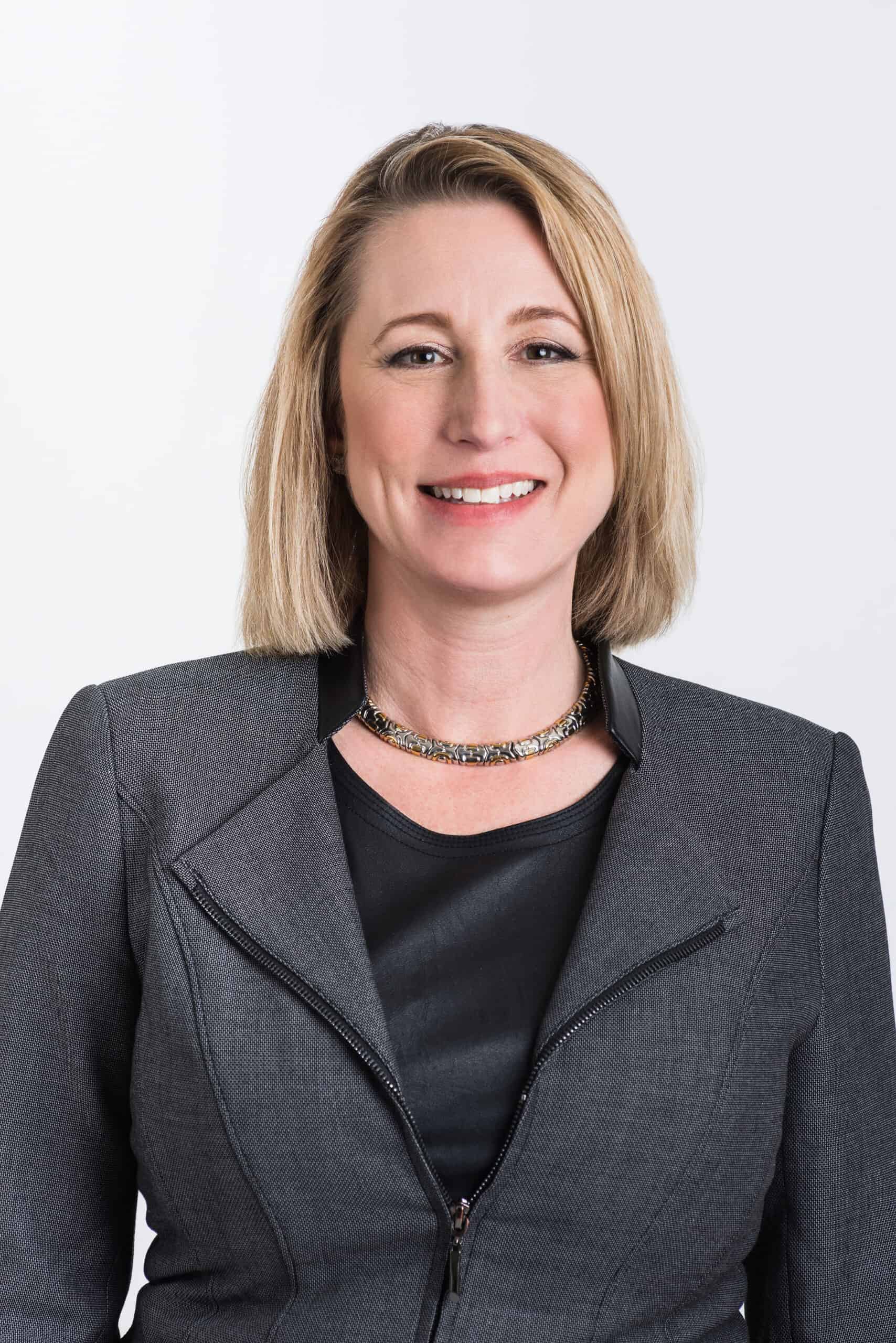 Confident woman in business attire at the WISE Symposium.