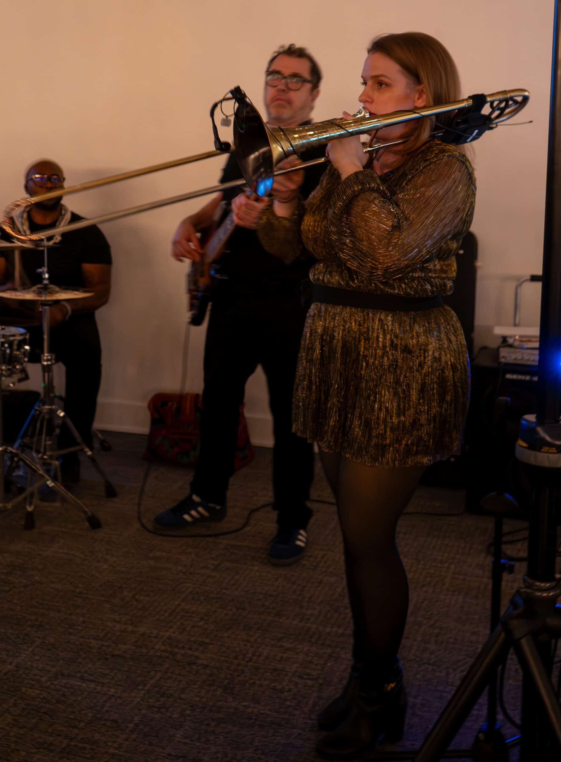 Female musician playing trombone during jazz band performance at SKY Armory.