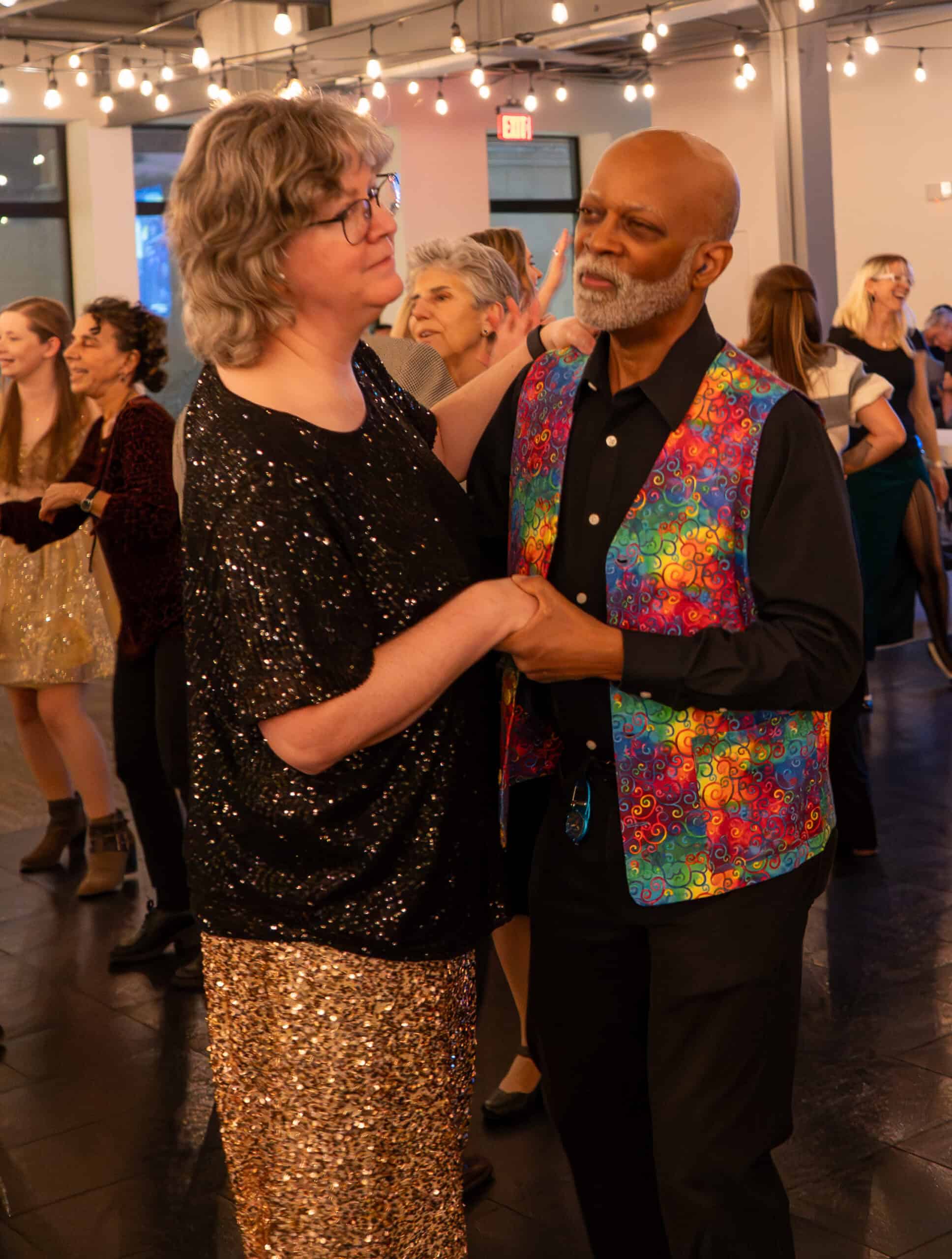 Couple dancing at SKY Armory with guests in background.