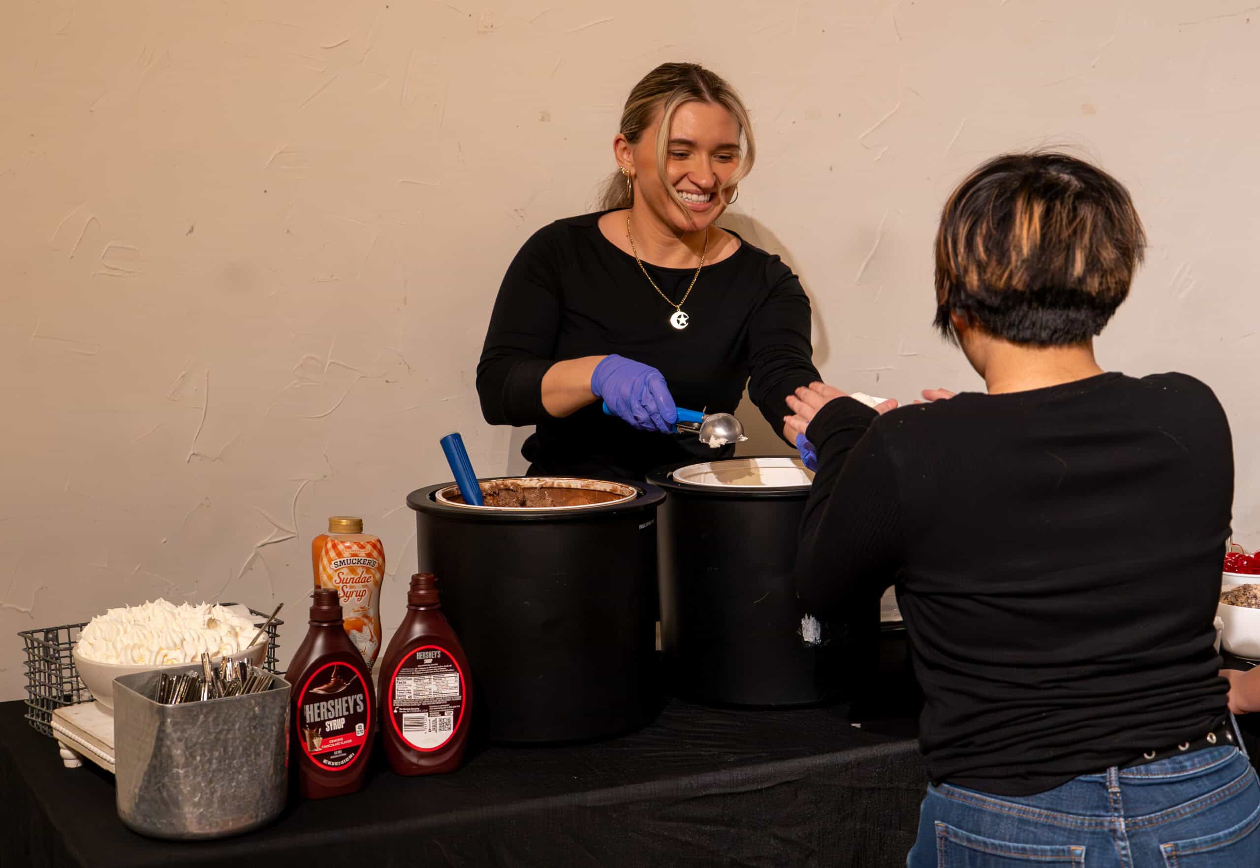 Smiling woman serving food at SKY Armory event with condiments and rice.