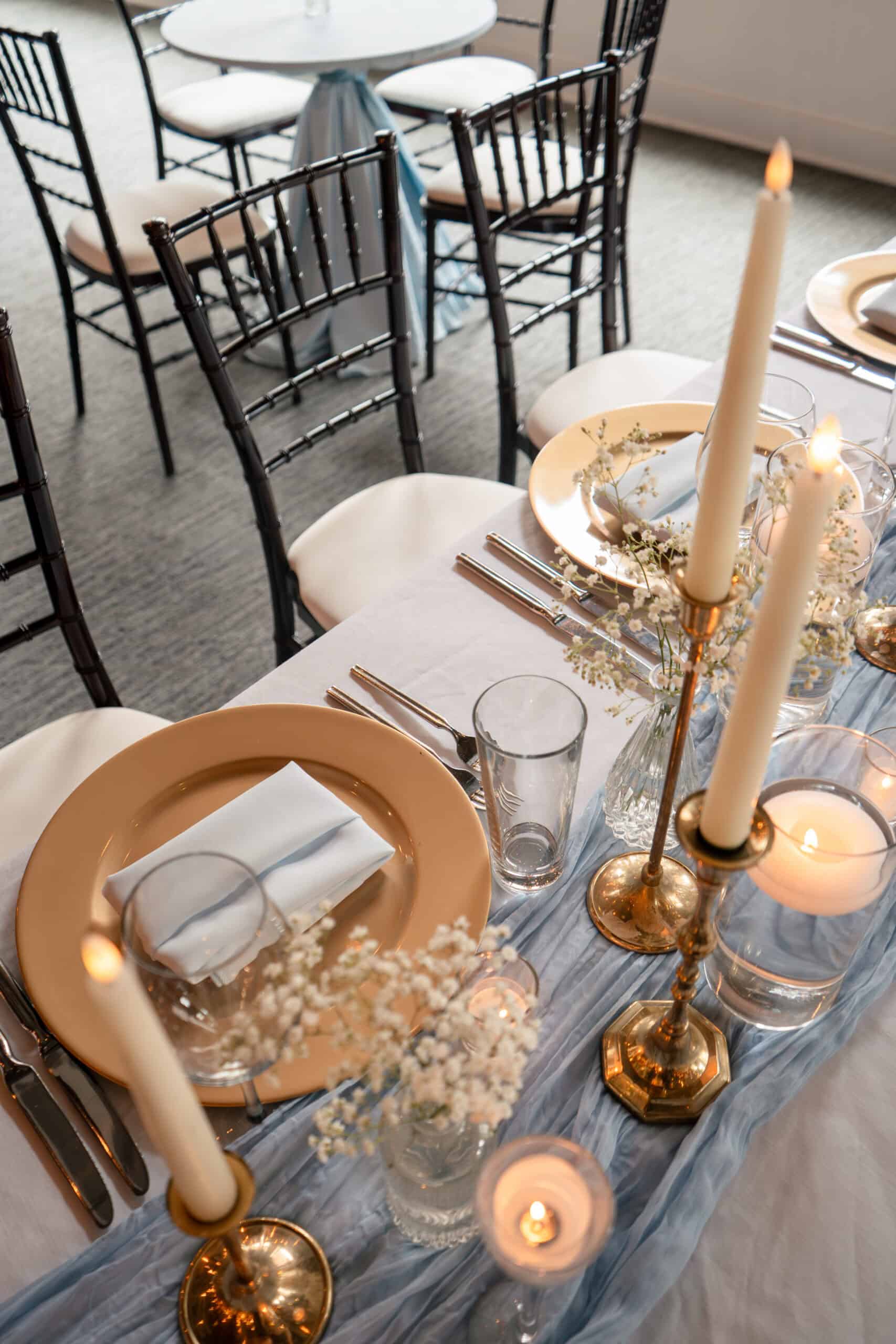 Elegant wedding table setup with candles, flowers, and fine dinnerware.