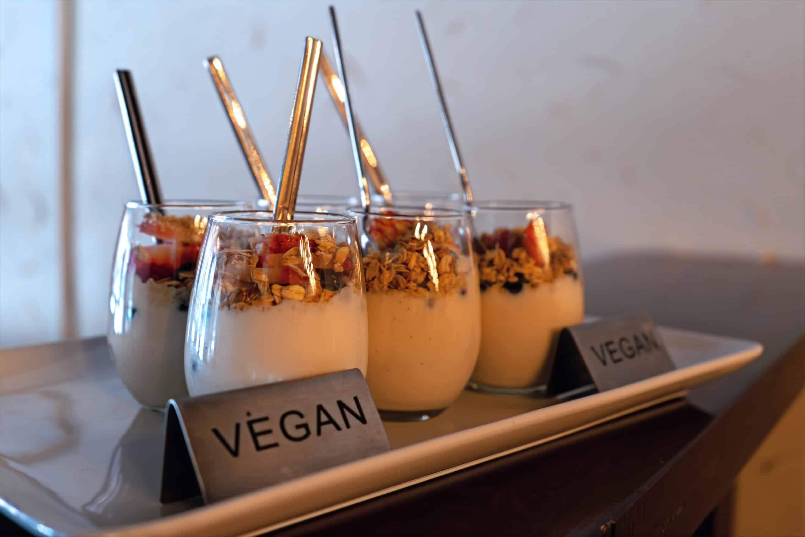 Three vegan dessert glasses with toppings on a tray at SKY Armory.