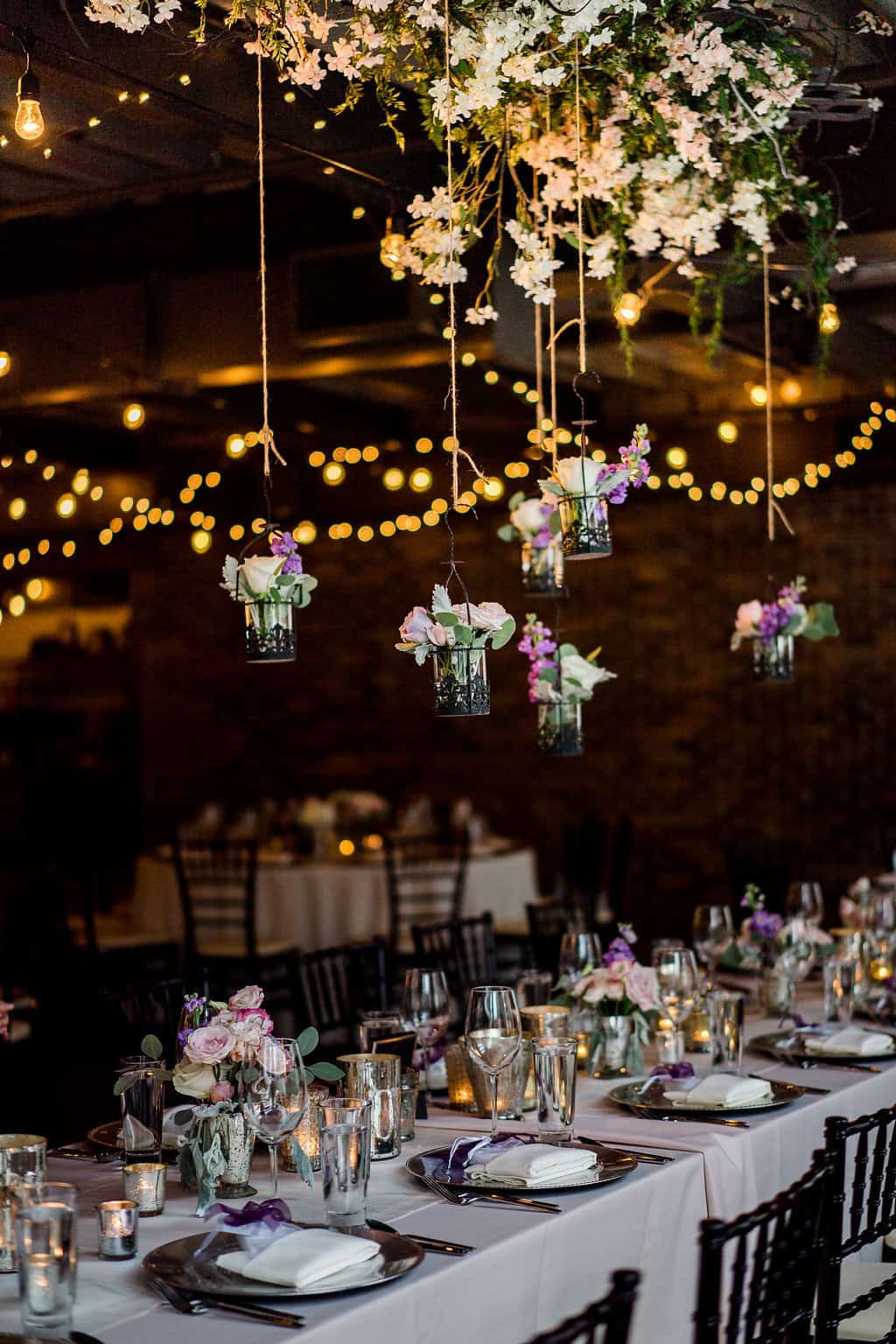 Beautiful wedding reception with floral centerpieces and hanging floral arrangements.