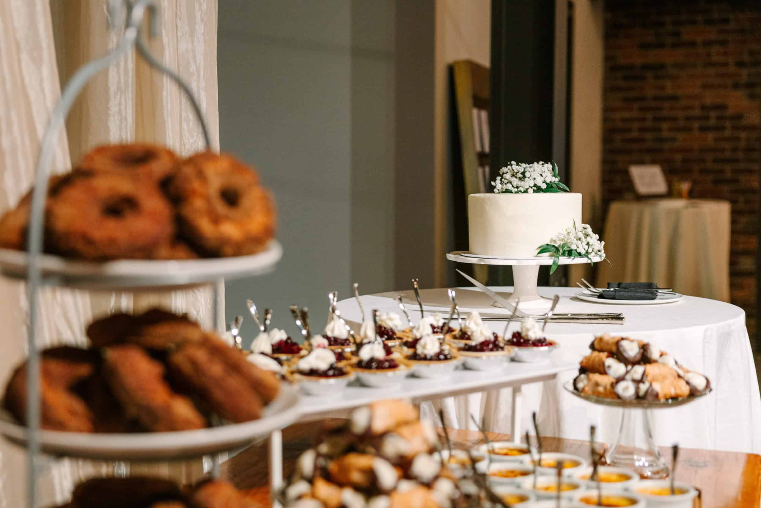 Dessert table with cake, cookies, and pastries at SKY Armory event.