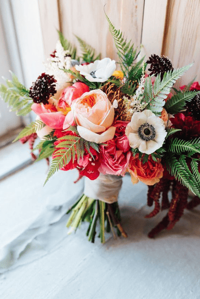 Beautiful floral wedding bouquet with roses, anemones, and greenery.