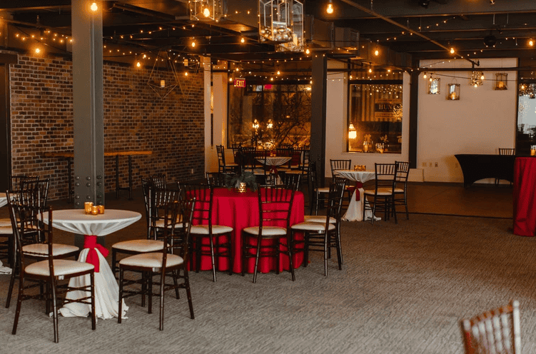 Indoor holiday event space with decorated tables and warm lighting at SKY Armory.
