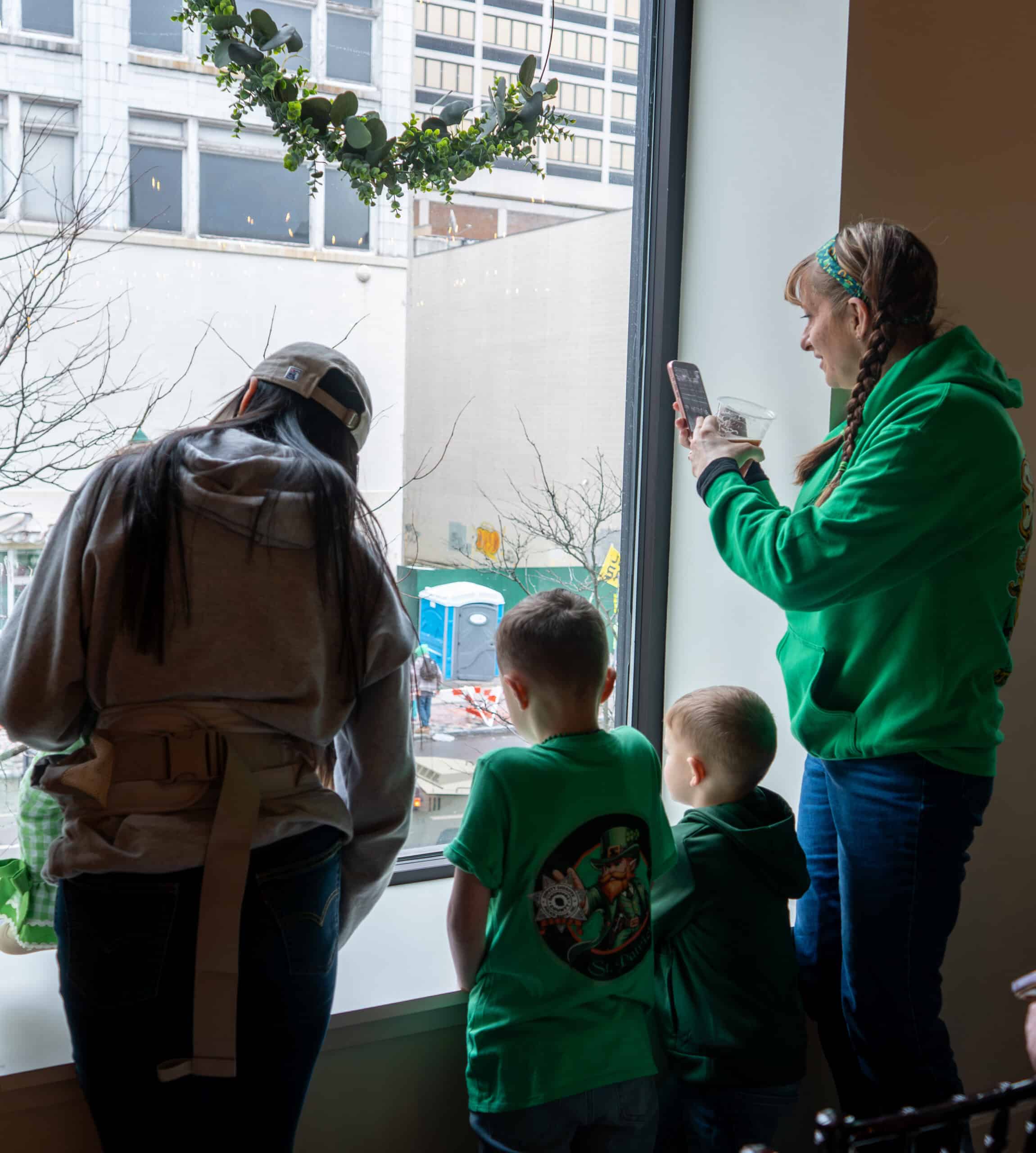 People viewing a cityscape through large indoor window at SKY Armory.